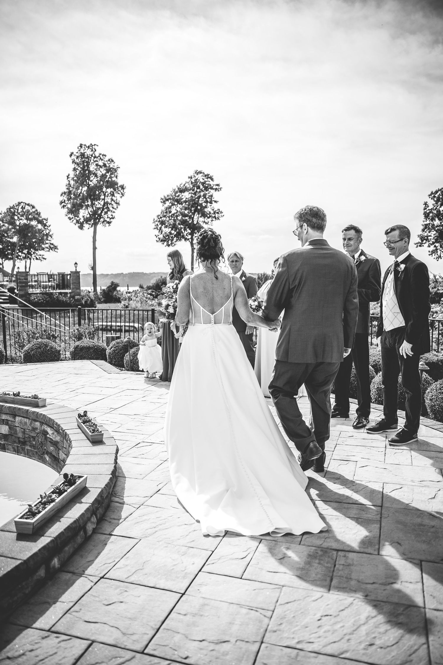 Black and white wedding ceremony photos captured on a stone patio with scenic backdrop.