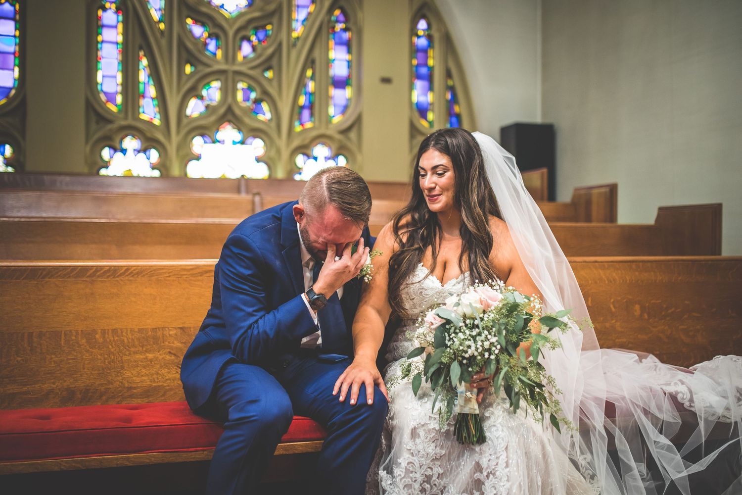 Wedding photography session inside a church featuring stained glass windows and gothic arches.