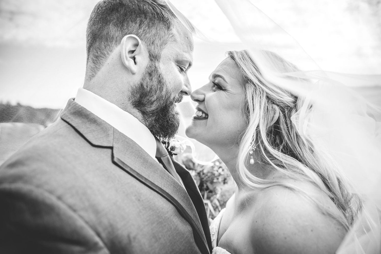 Black and white romantic portrait with flowing veil creating dreamy atmosphere.