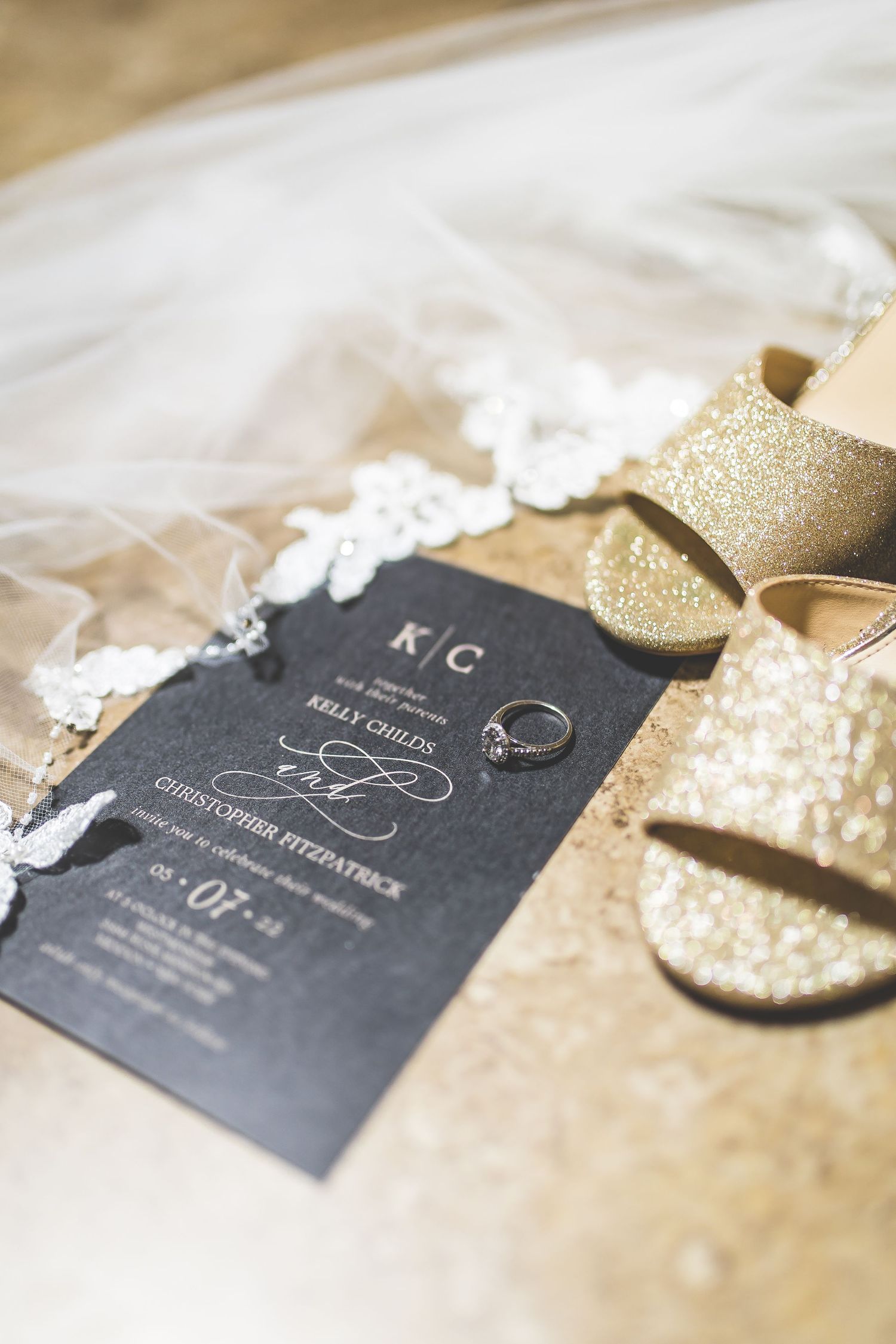 Elegant black and gold wedding invitations with lace details.
