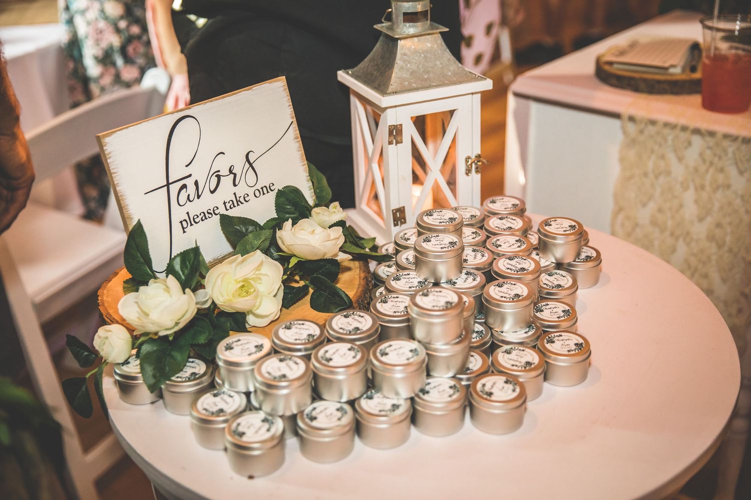 Wedding reception decor featuring mason jar candle holders and floral arrangements.