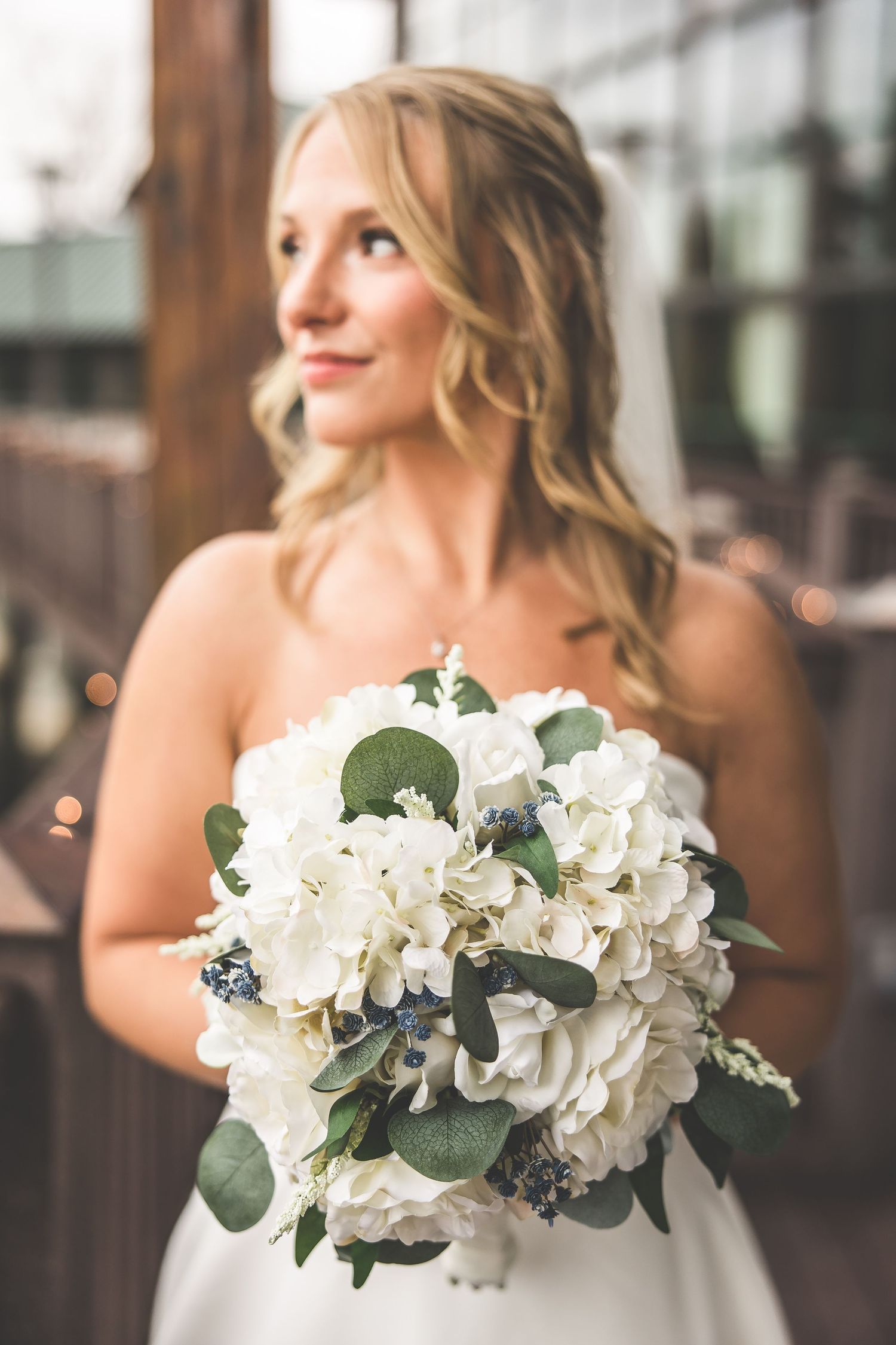 Close-up of bride holding classic white and green bouquet on deck.