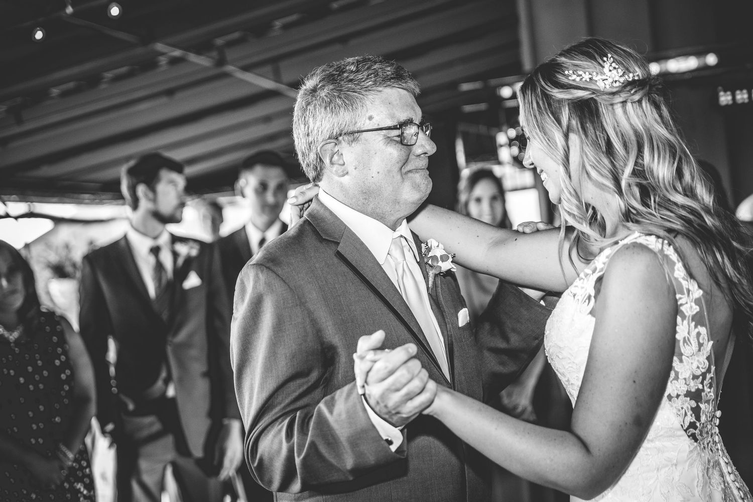 Black and white photo of wedding guests watching a couple's first dance.