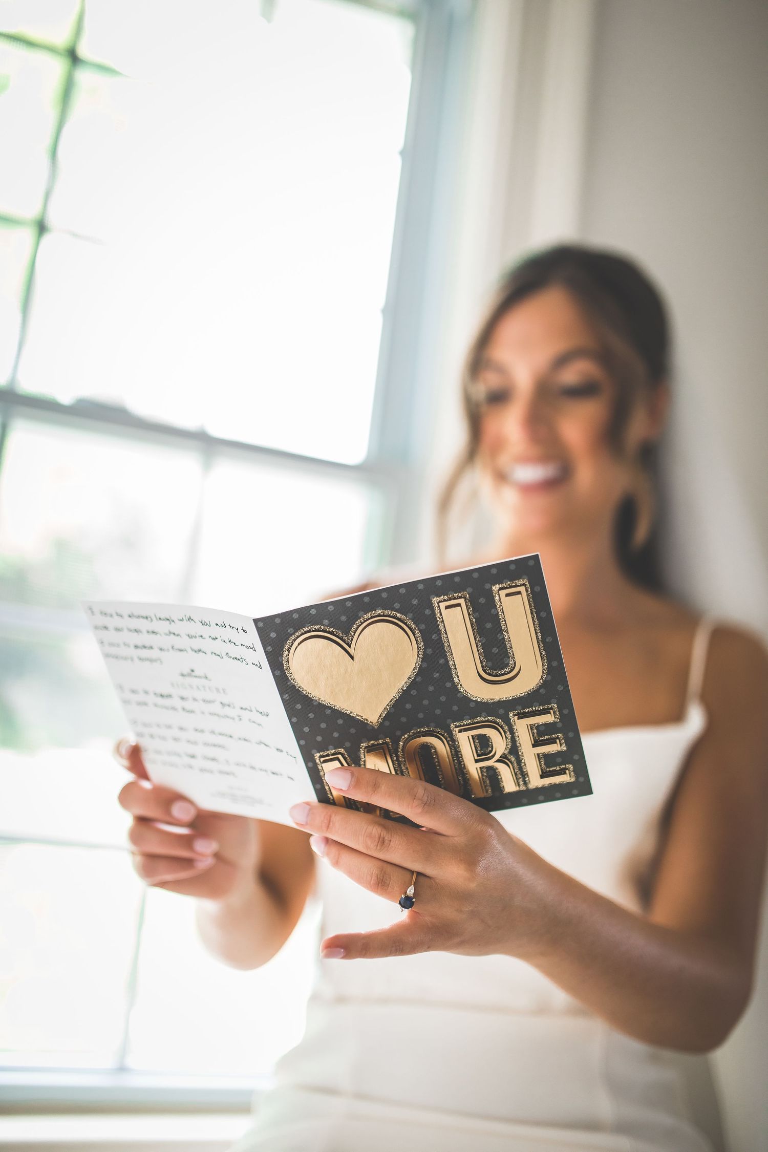Close-up of hands holding a special wedding day message card with gold lettering.
