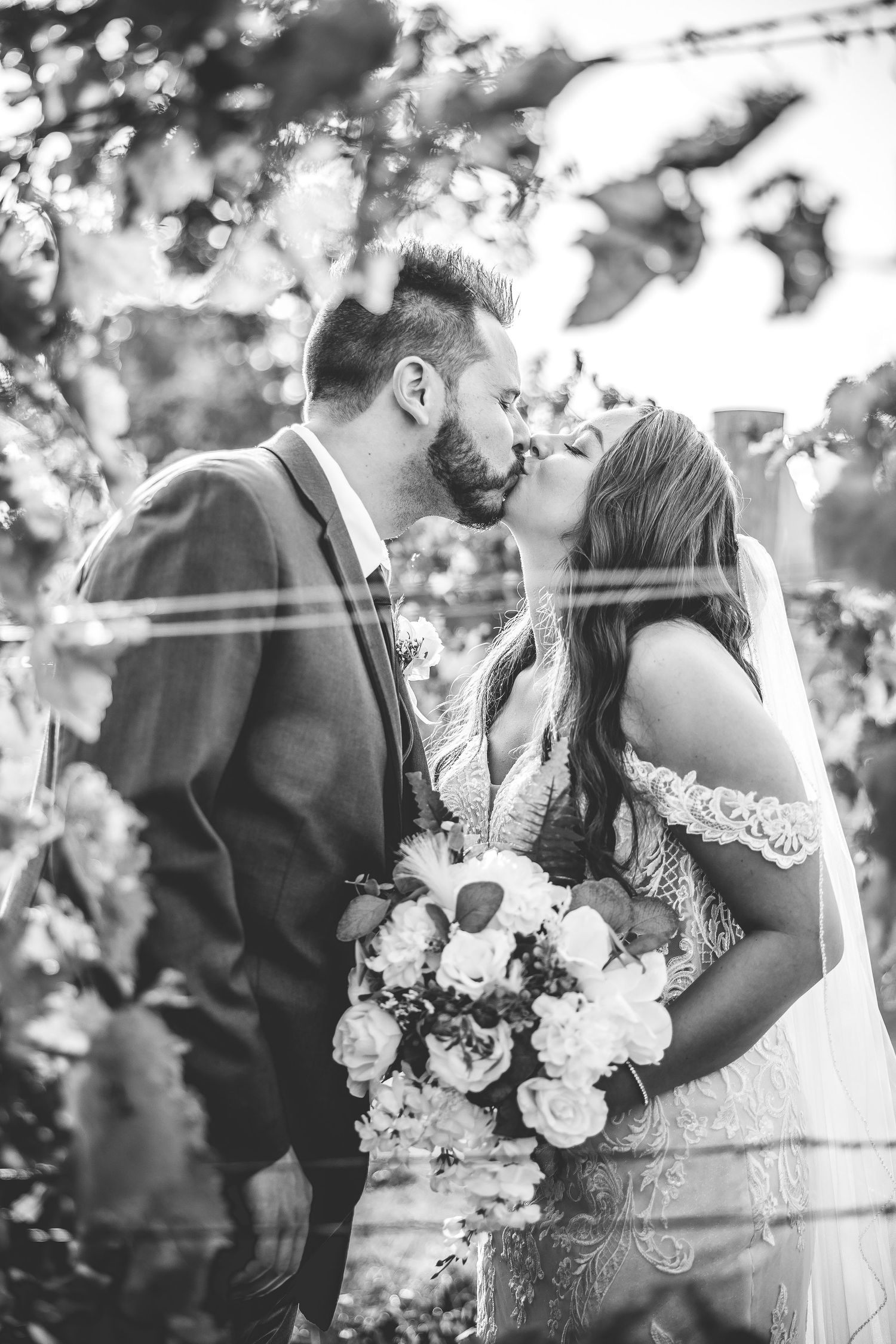Black and white wedding photos showing intimate moments with bouquet of white roses.