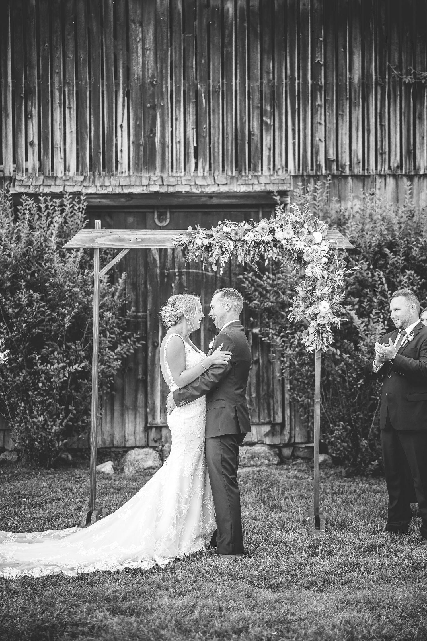 Black and white series of ceremony moments against rustic barn backdrop.