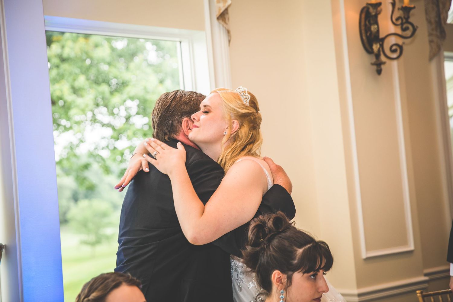 Wedding reception guests sharing emotional moments during dinner celebration.