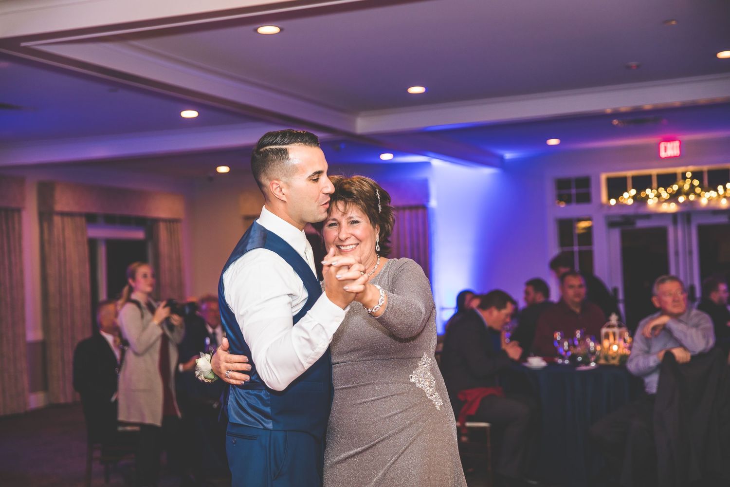 Purple and blue lighting sets the mood for a romantic wedding reception dance.