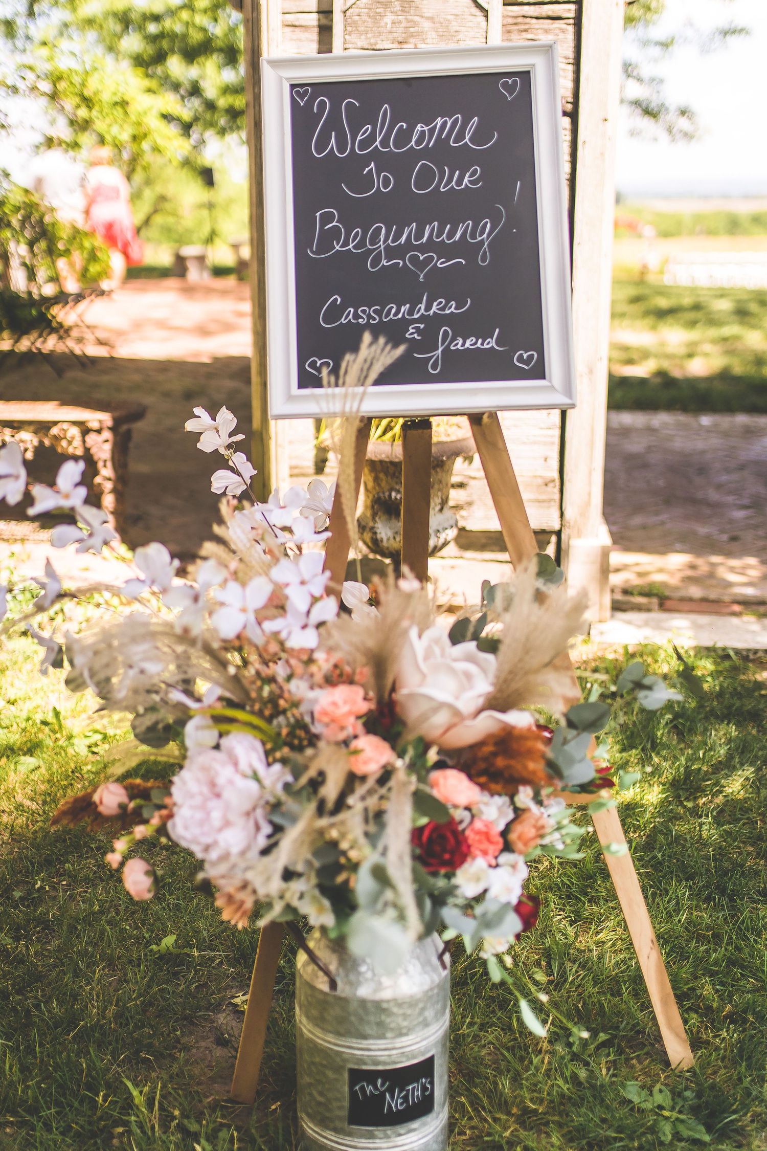 Rustic wedding decor features chalkboard signs and floral arrangements in galvanized buckets.