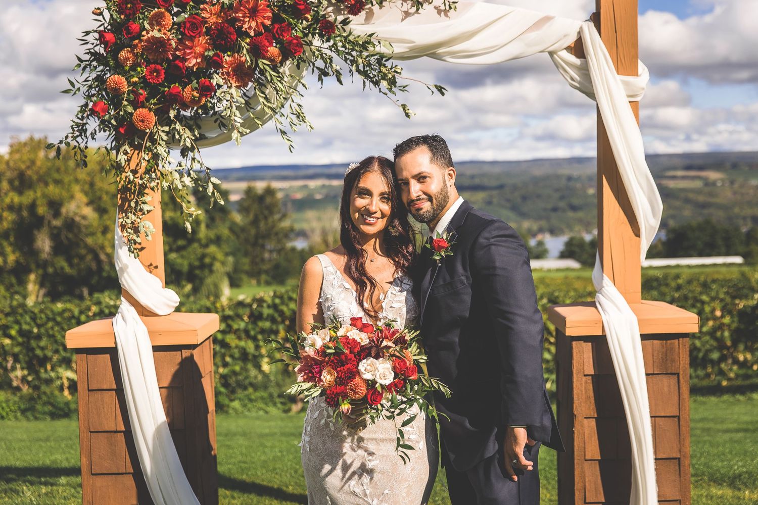 Intimate wedding ceremony at a hilltop venue with floral decorations.