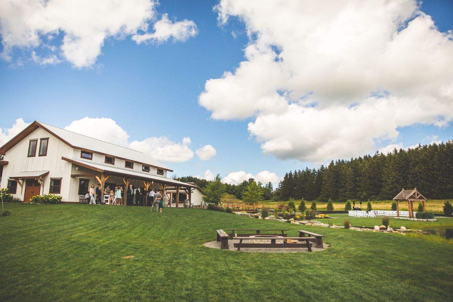Panoramic view of a rustic barn wedding venue set on a rolling hillside.