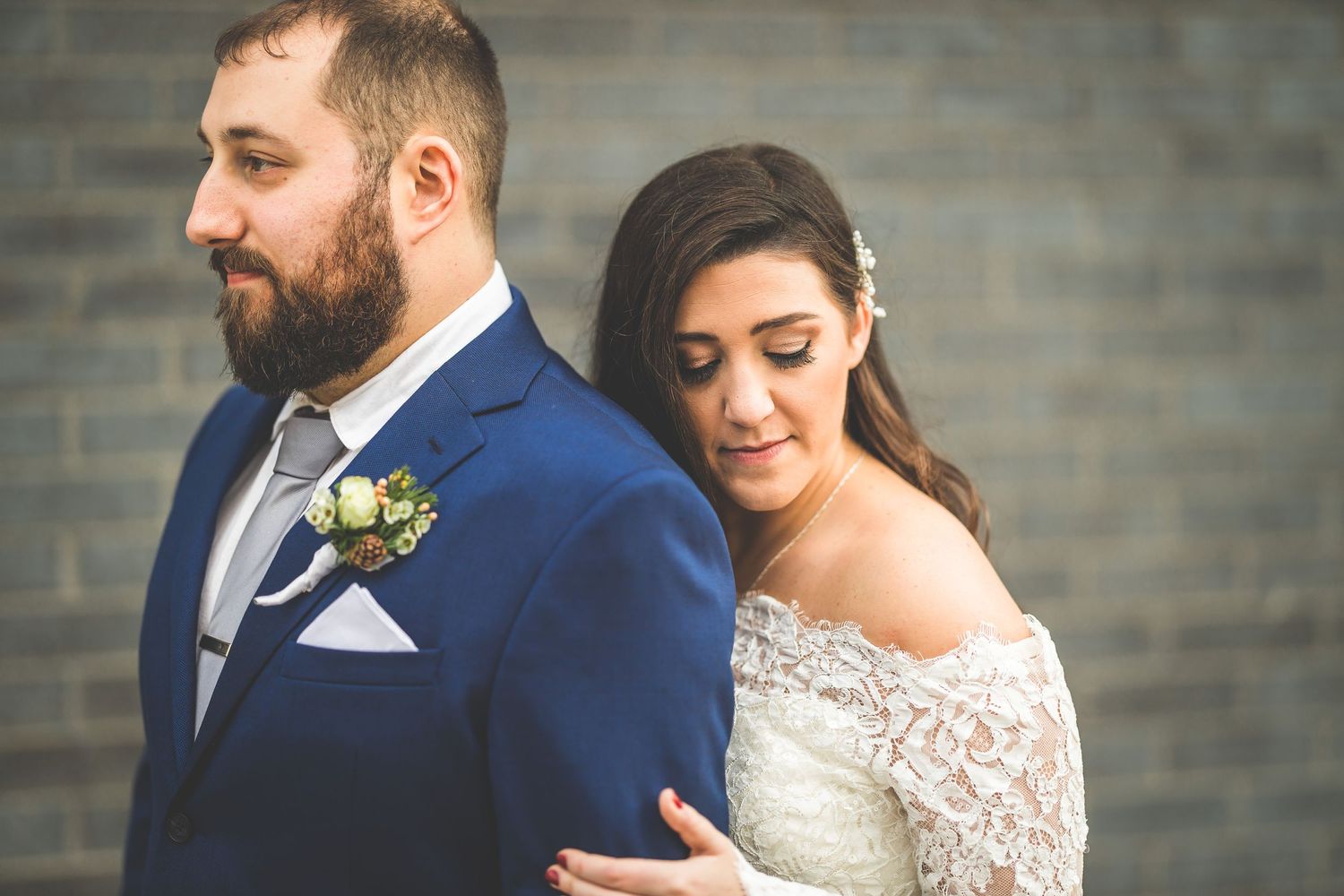 Newlywed couple sharing an intimate moment against an urban backdrop.