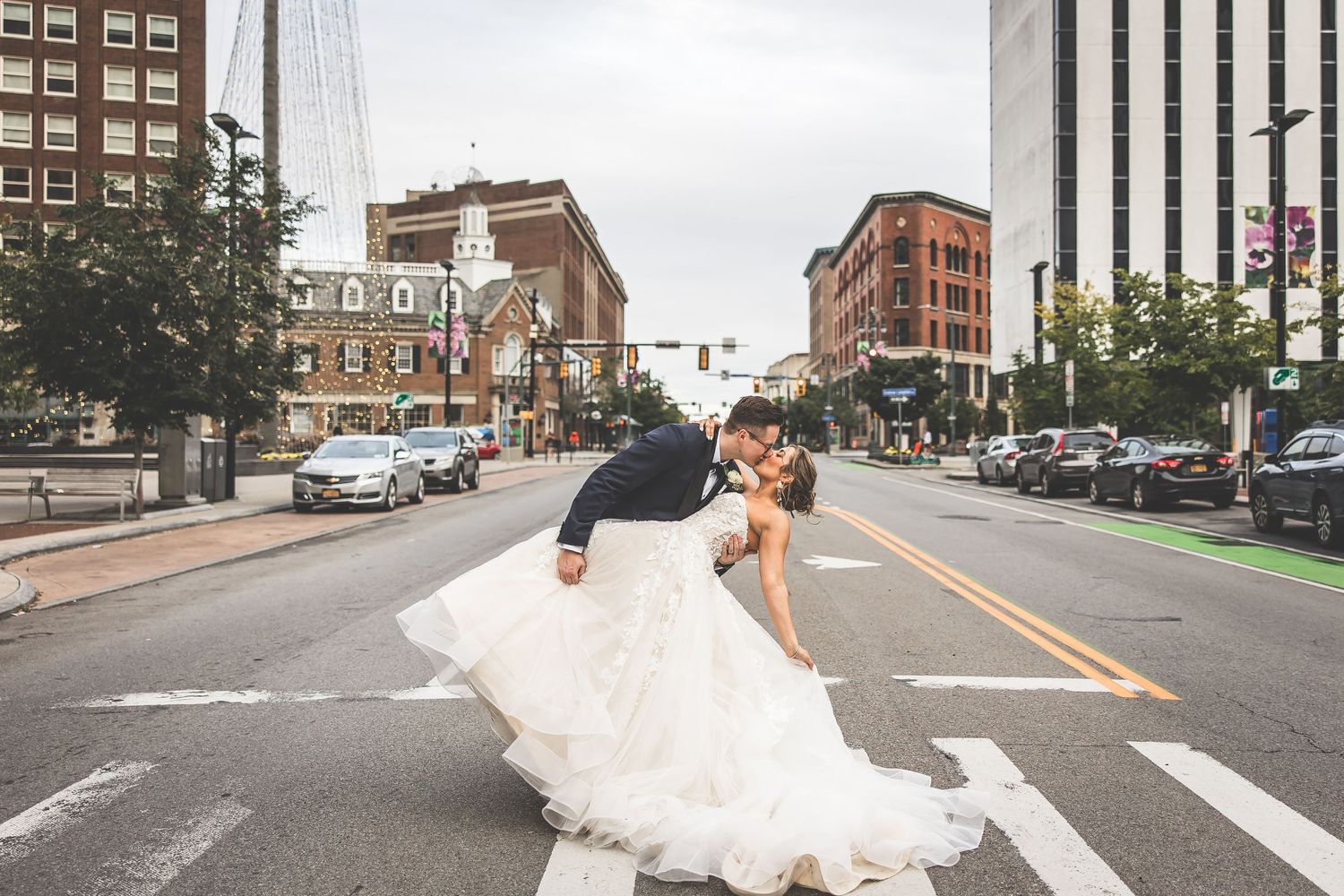Wedding couple walking and posing playfully on an empty city street.