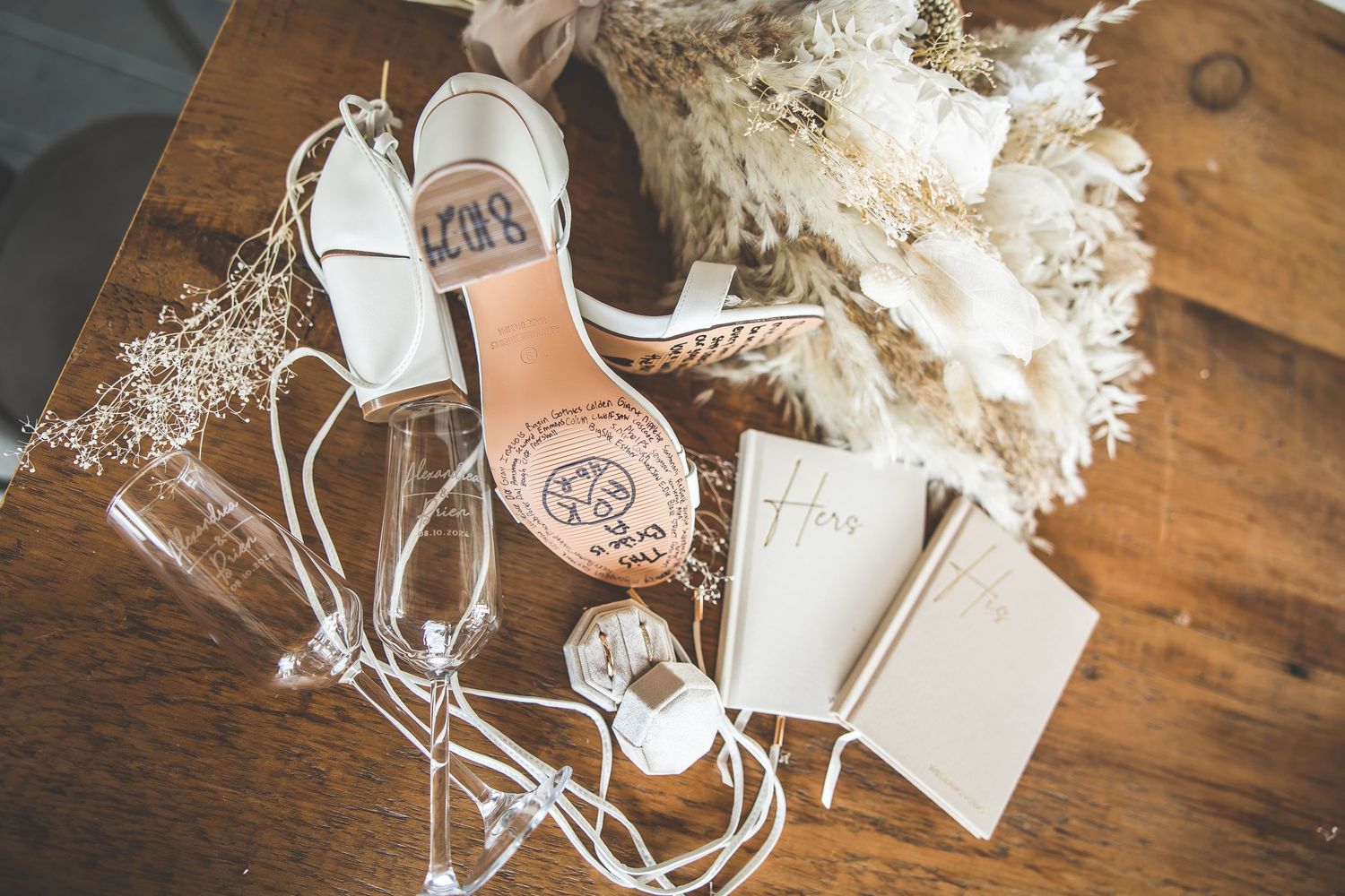 Wedding details including delicate white floral arrangements and decorative elements on wooden surface.