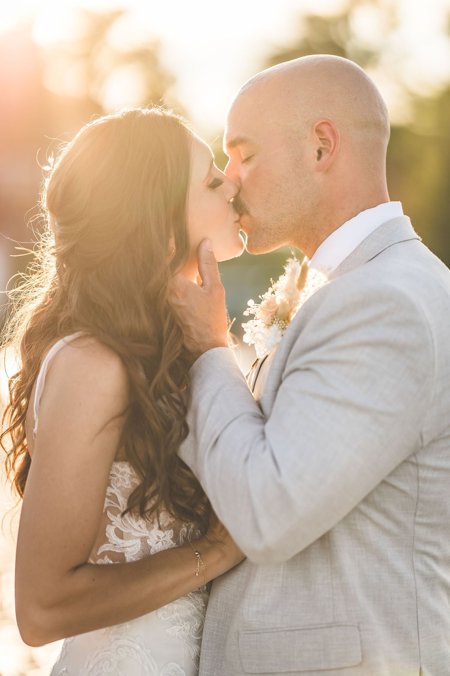 Intimate sunset wedding portraits with golden backlighting and soft focus.