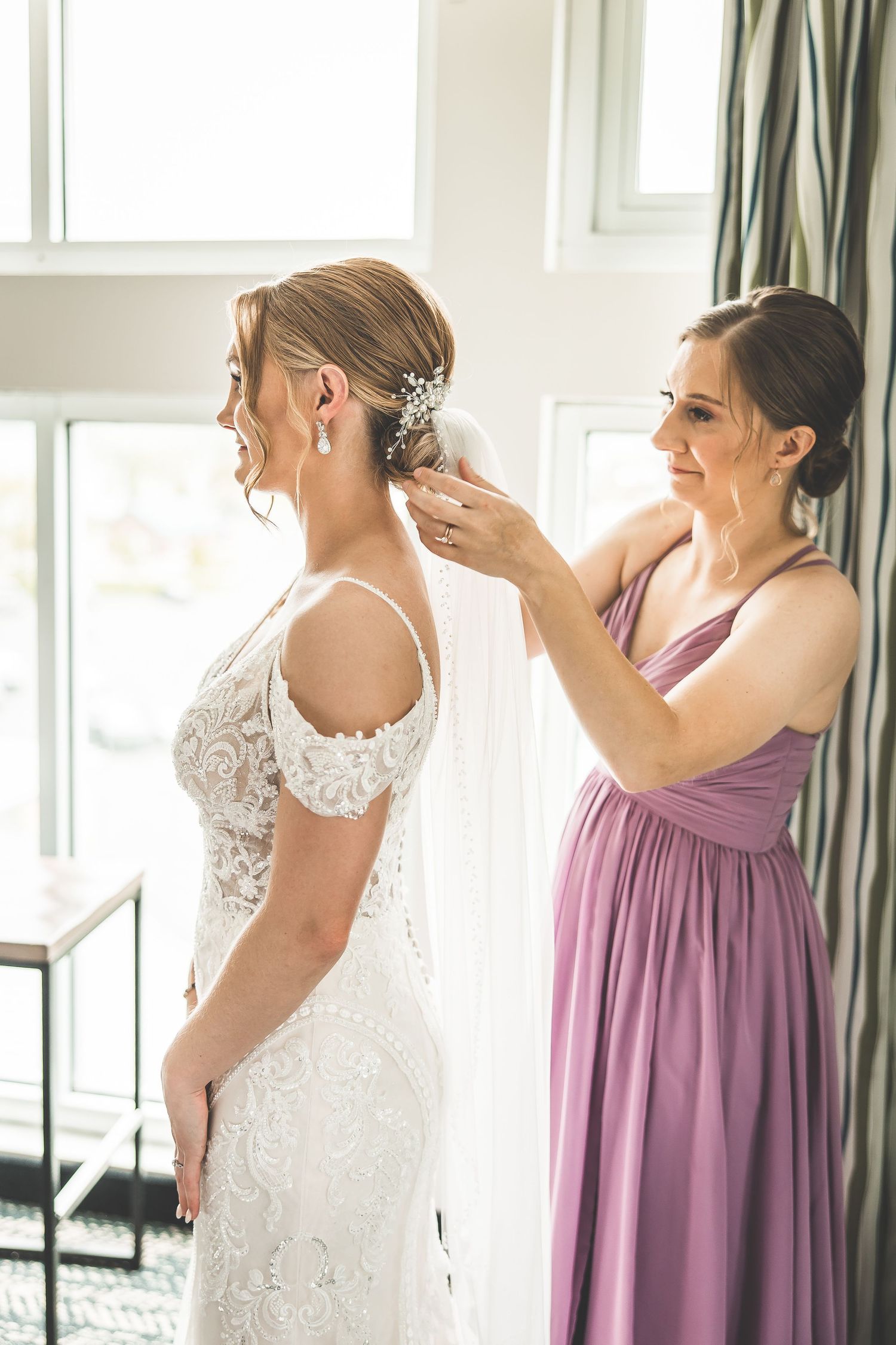 Wedding preparation scene showing final touches being added to bridal hairstyle.