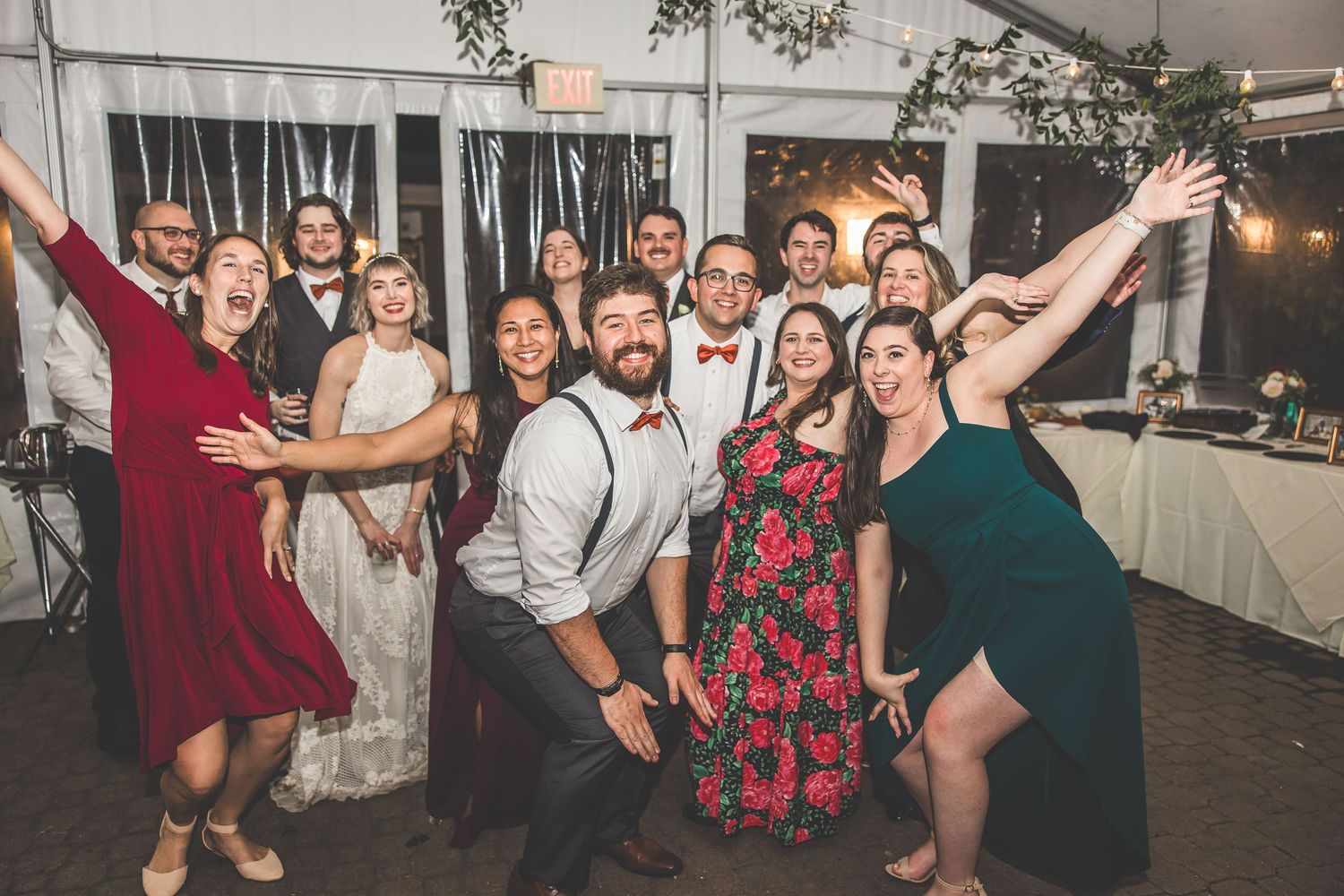 Large group of wedding guests dancing and celebrating together on a dance floor.