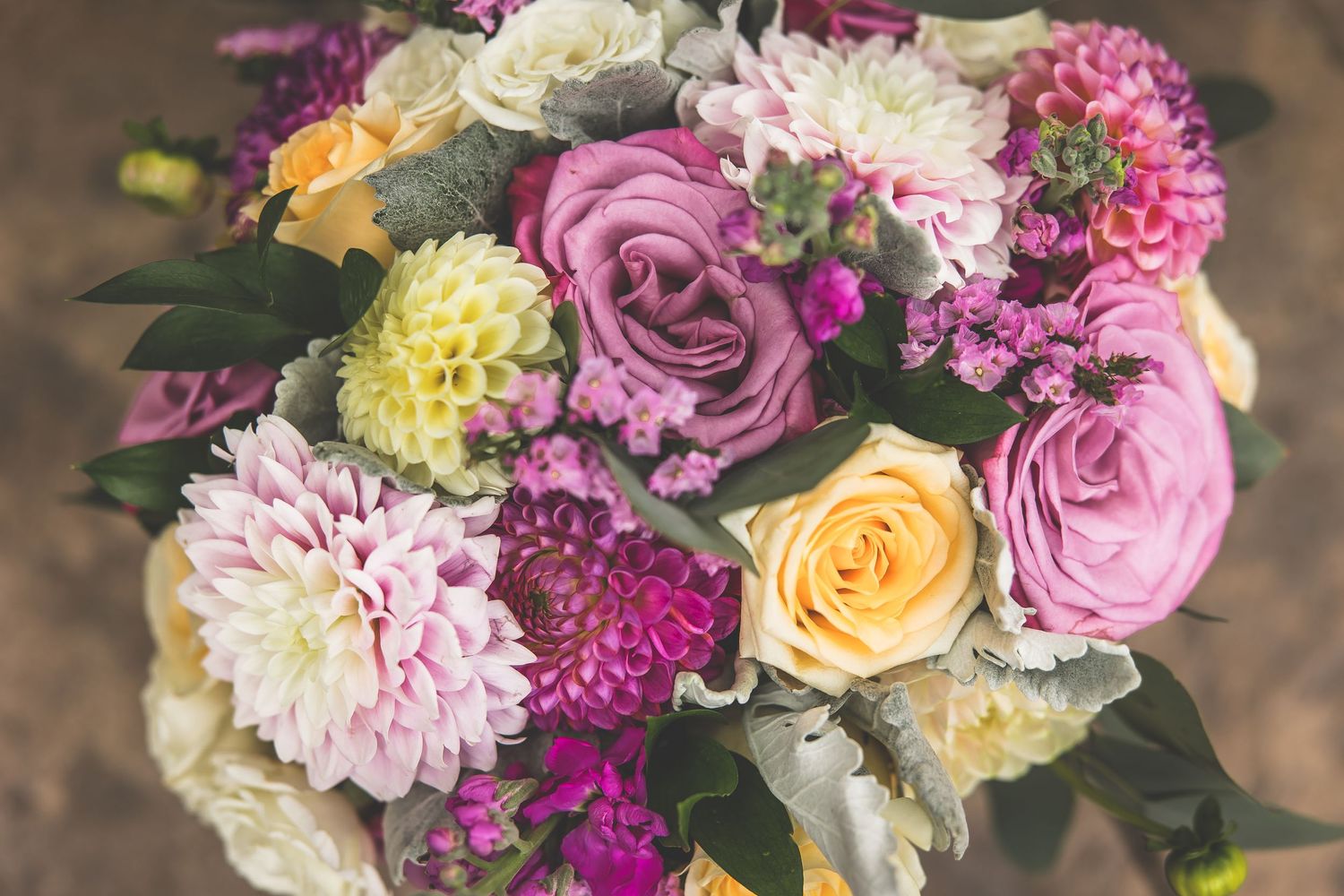 Stunning bridal bouquet featuring pink roses, yellow flowers, and mixed florals.