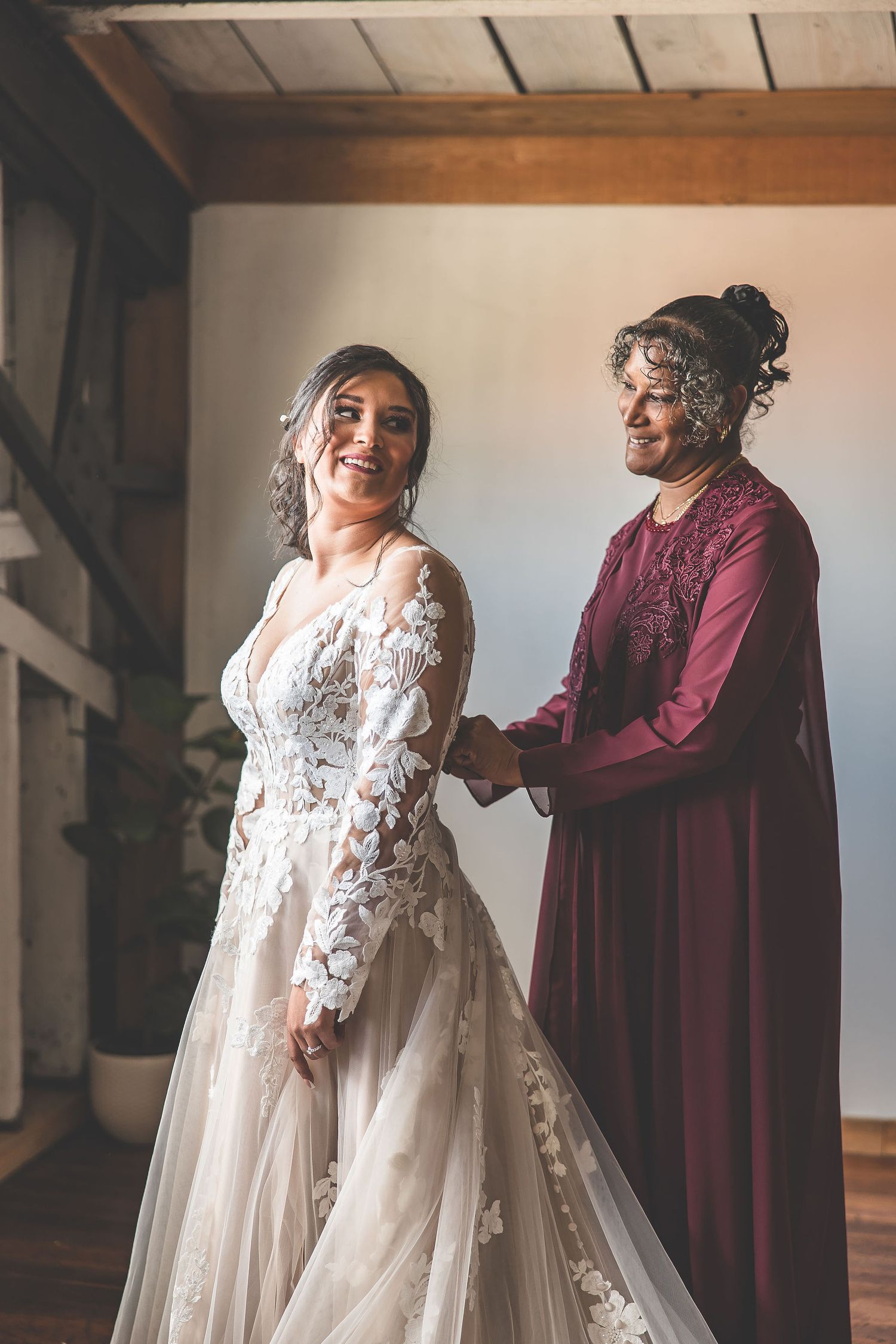 Joyful moment captured during wedding preparations in rustic wooden interior.