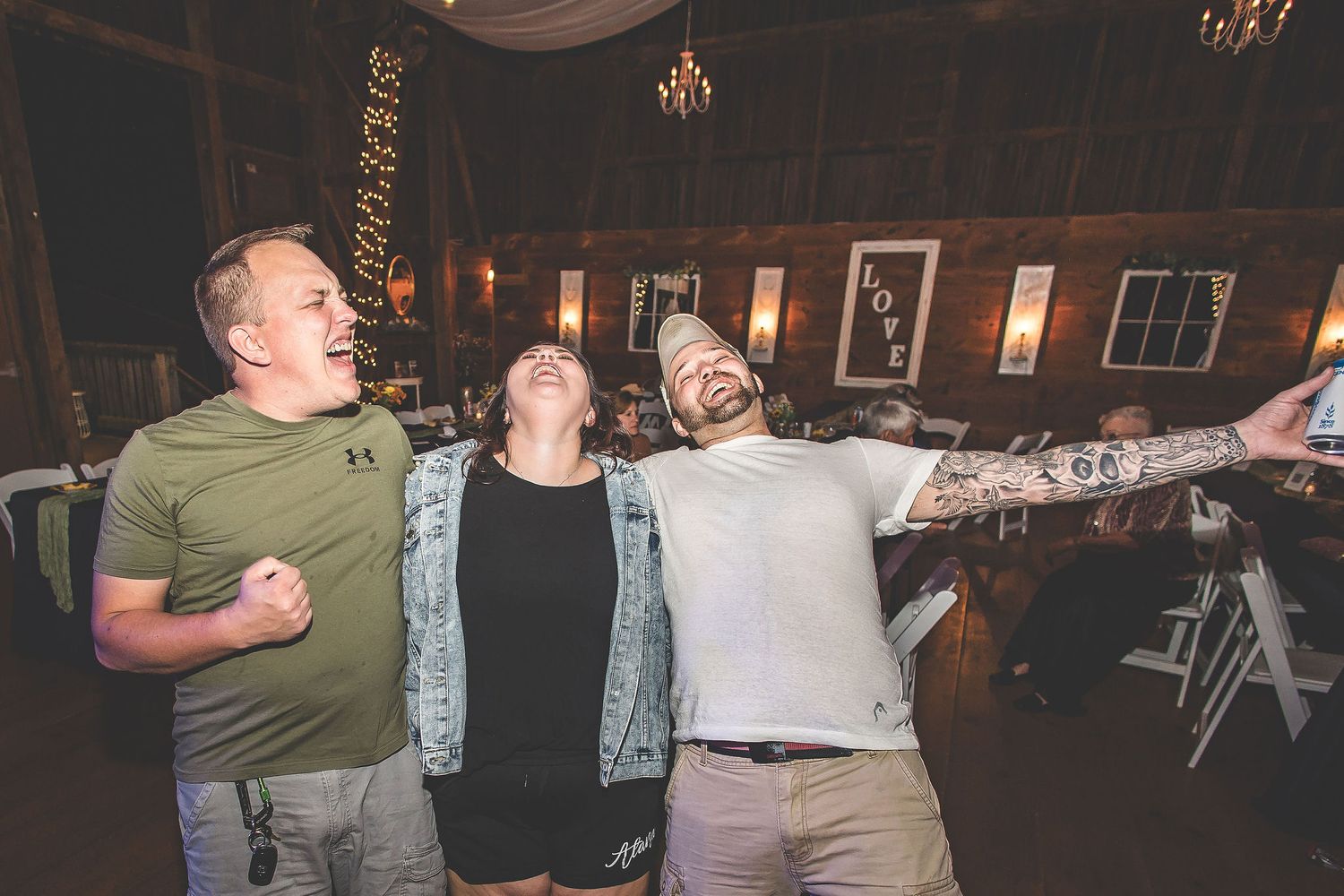 People dancing and having fun at a dimly lit indoor wedding reception.