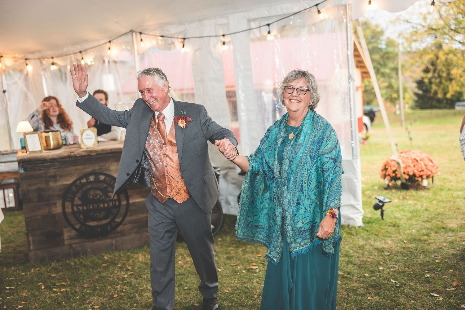 Wedding reception tent setup with string lights and white fabric creating a romantic outdoor atmosphere.