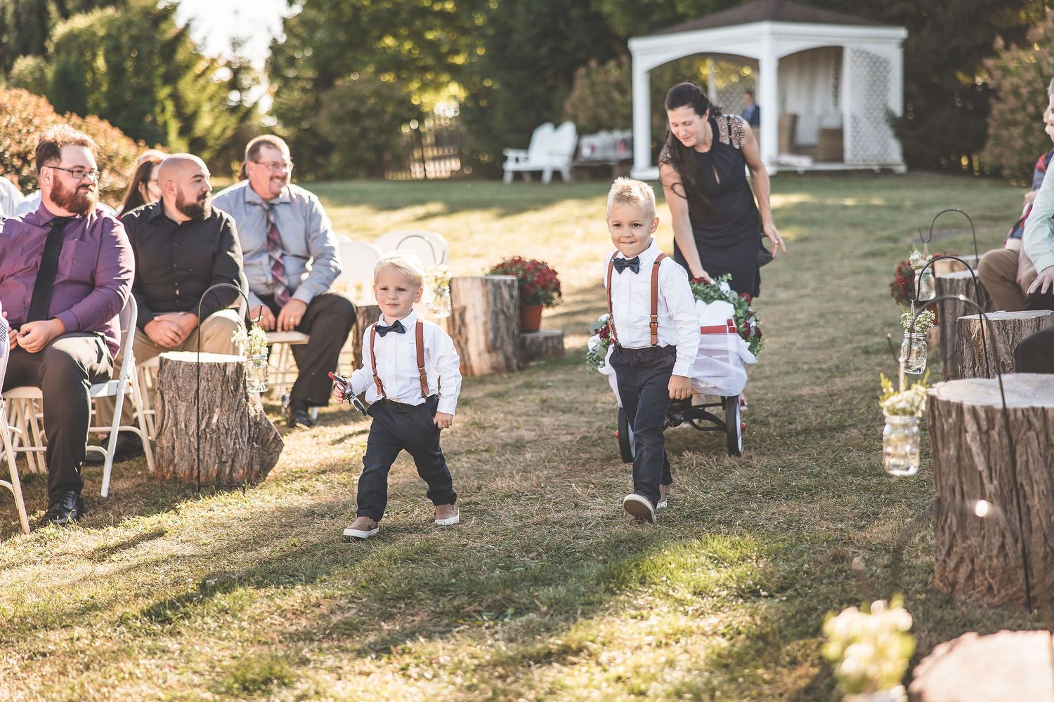 Wedding guests enjoy casual moments on lawn during outdoor celebration.