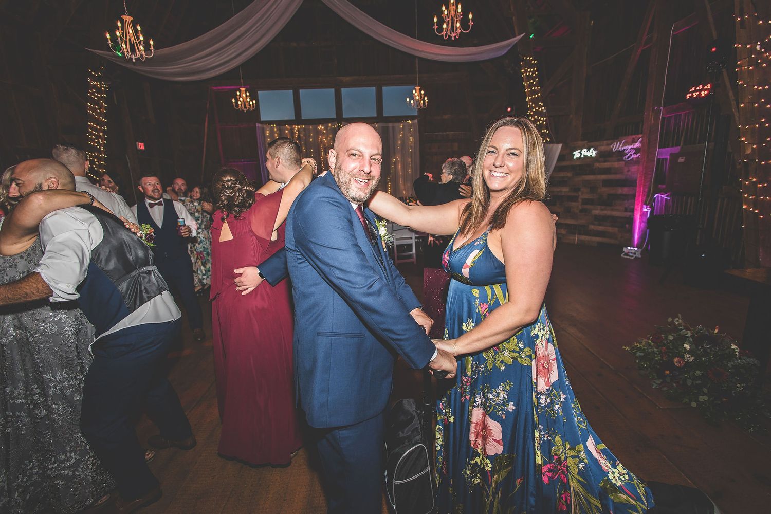 Lively dance floor scene at wedding reception with guests enjoying the celebration.