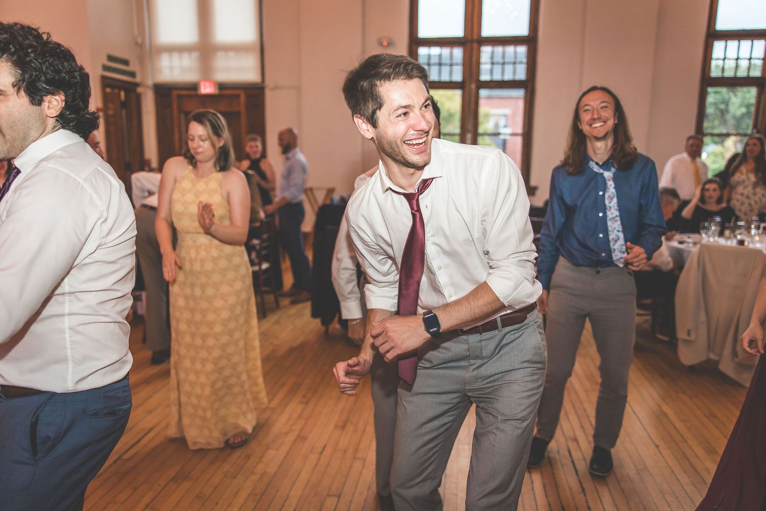 Joyful wedding guests dancing and celebrating on the dance floor at a reception.