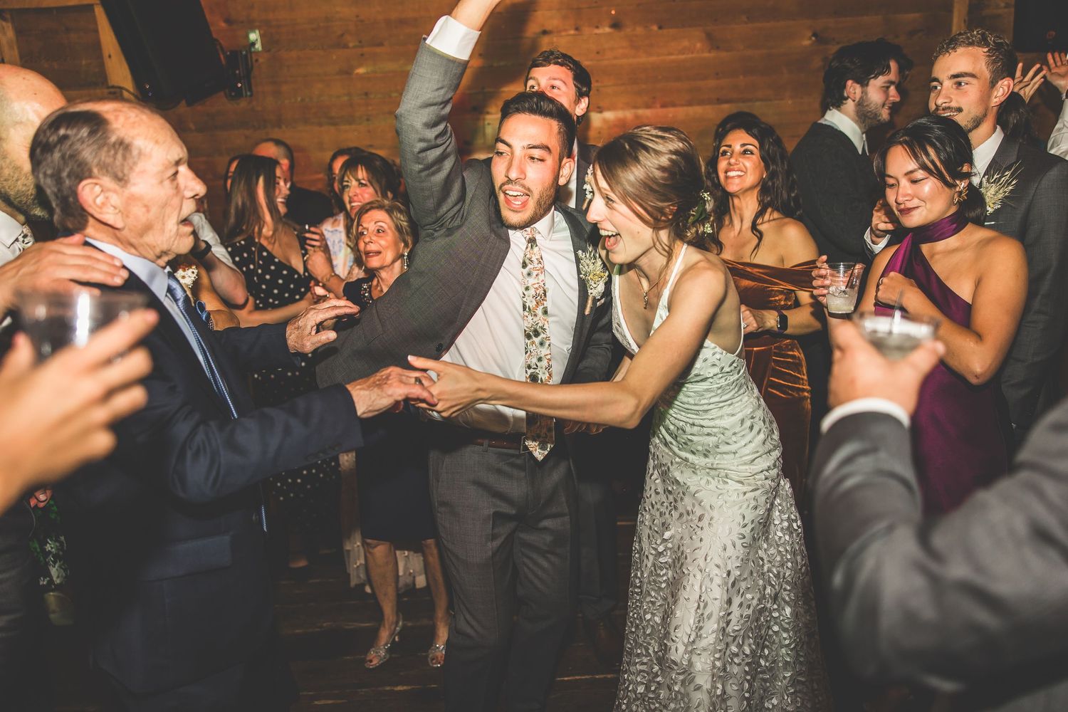 Lively wedding reception dance floor filled with guests celebrating and dancing.