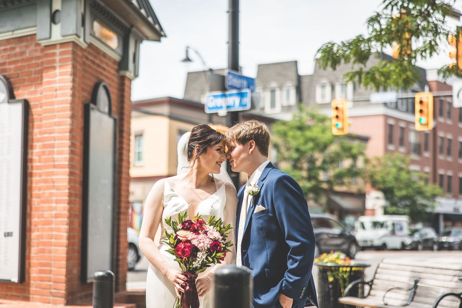 Wedding photography session on city street with brick buildings in background.