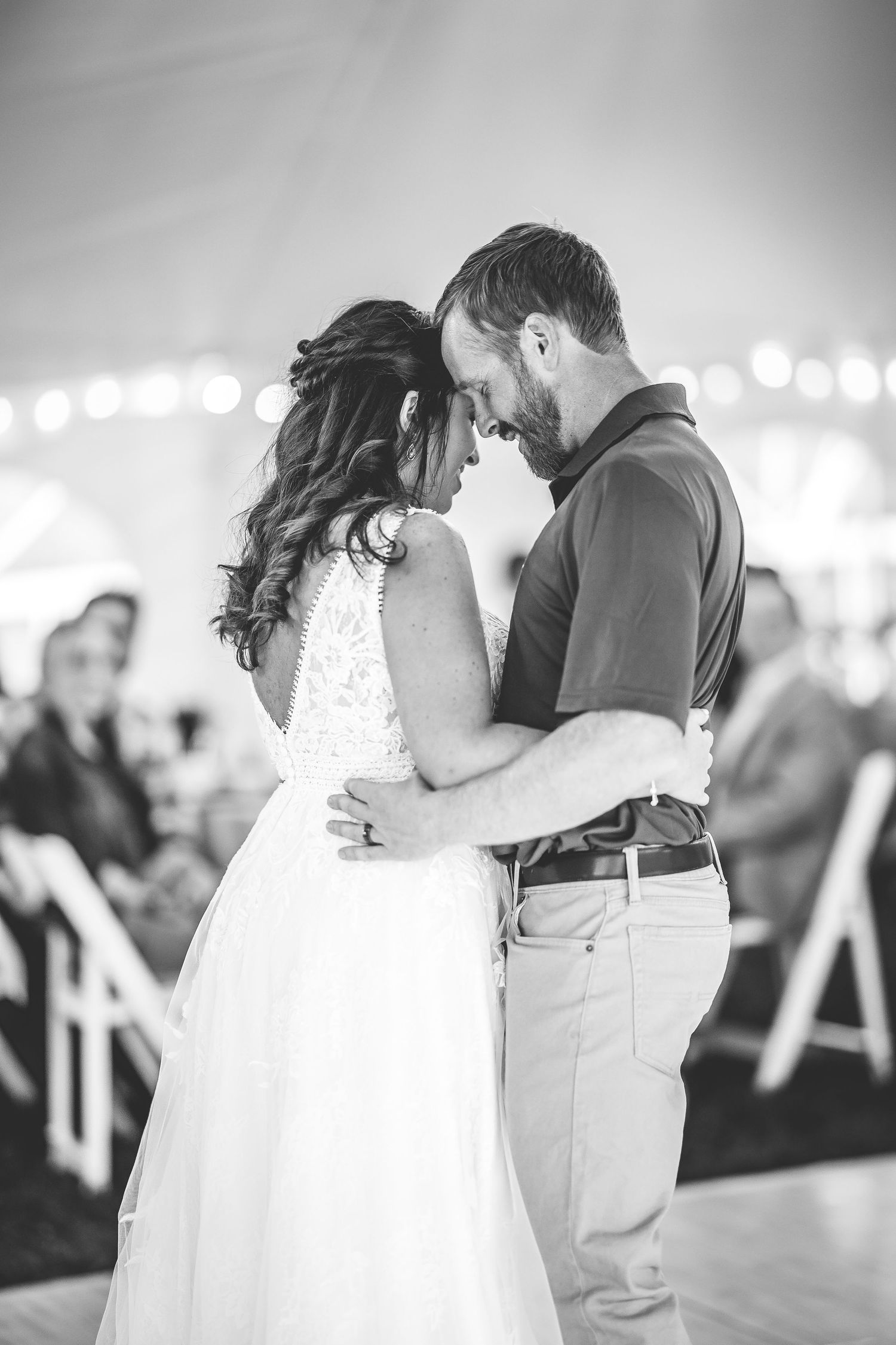Black and white wedding photos capture intimate dance moments under a reception tent.