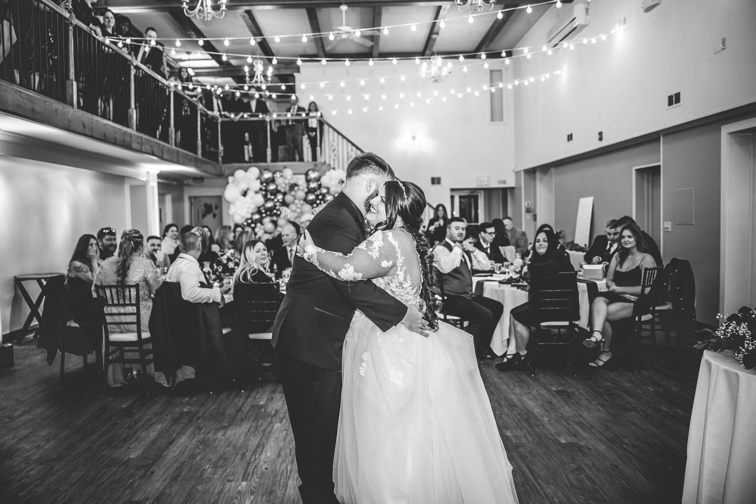 Wedding reception dance floor moments with string lights and guests in attendance.