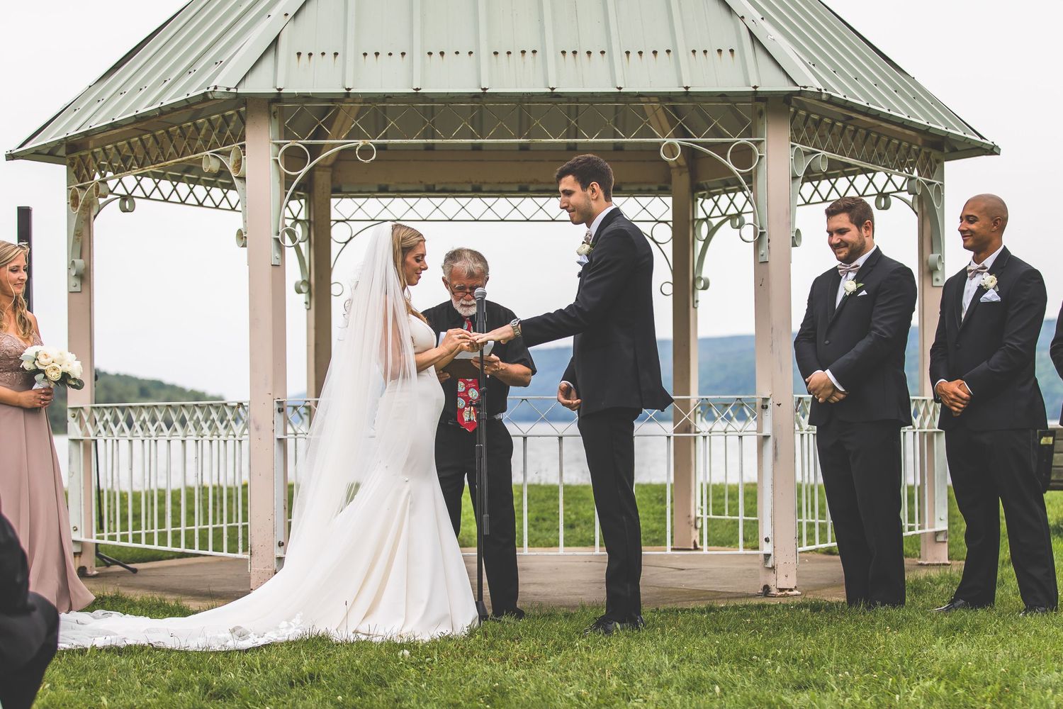Scenic outdoor wedding venue featuring white gazebo against mountain landscape backdrop.
