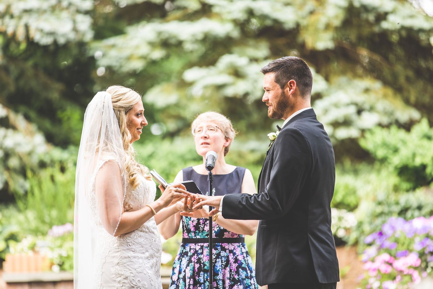 Emotional wedding ceremony moment captured in a beautiful garden setting with blooming flowers.