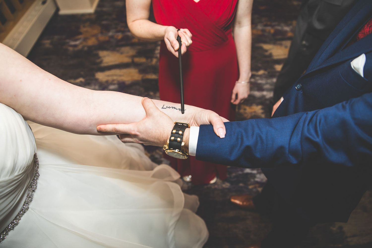 Close-up details of hands exchanging rings during wedding ceremony.