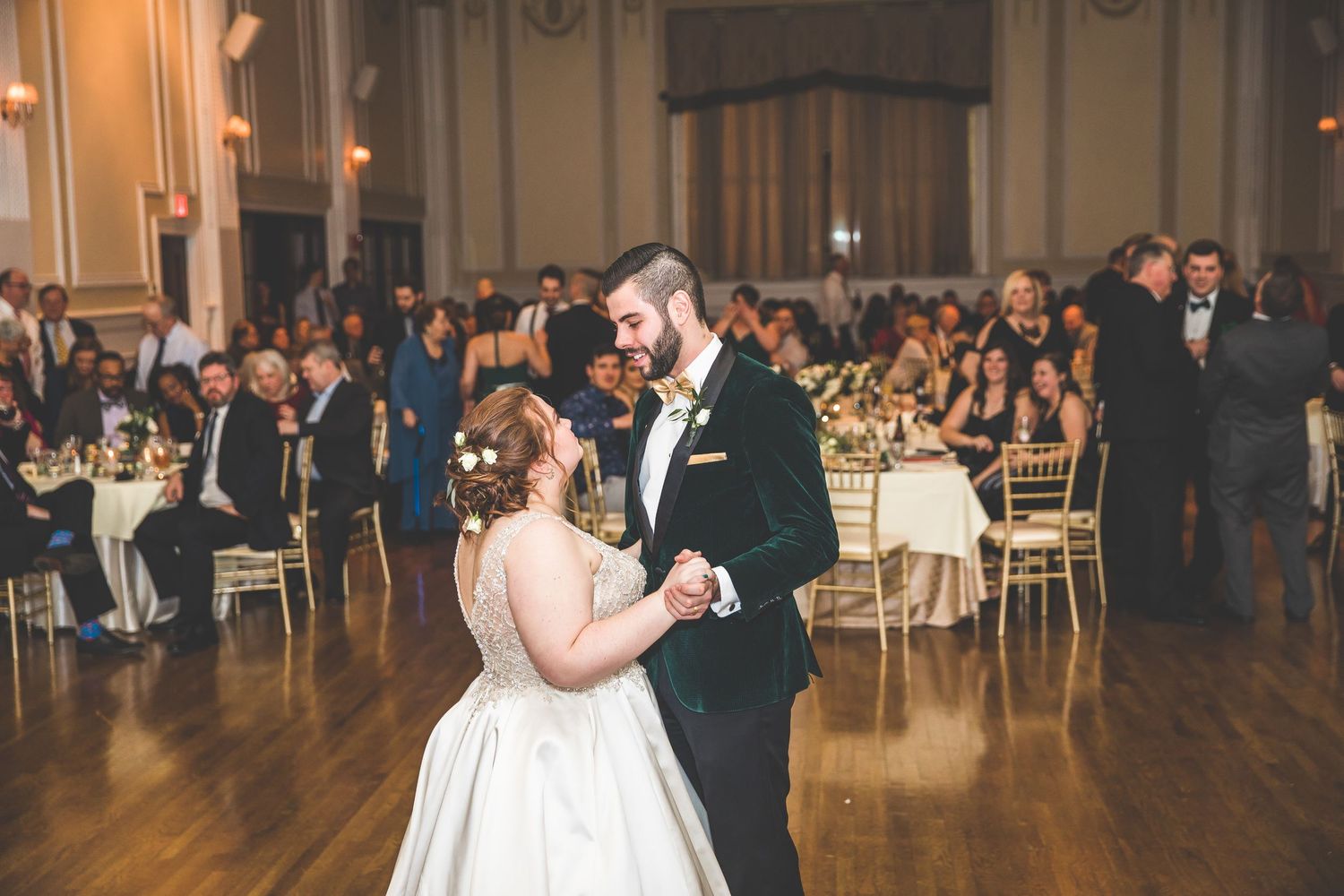 Couples share romantic dances across a spacious ballroom during an elegant evening wedding celebration.