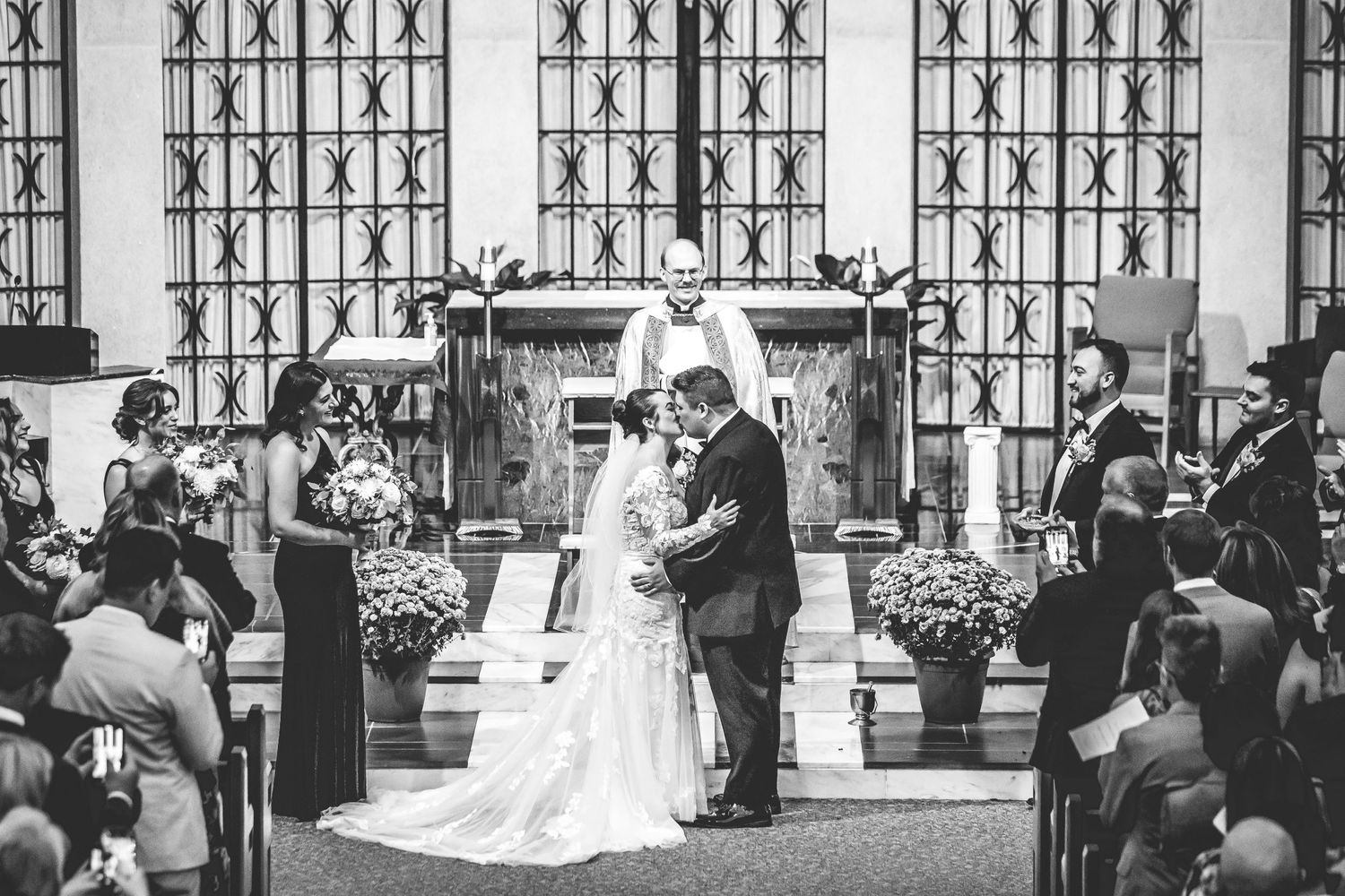 Black and white photo of wedding guests seated in church pews during ceremony.