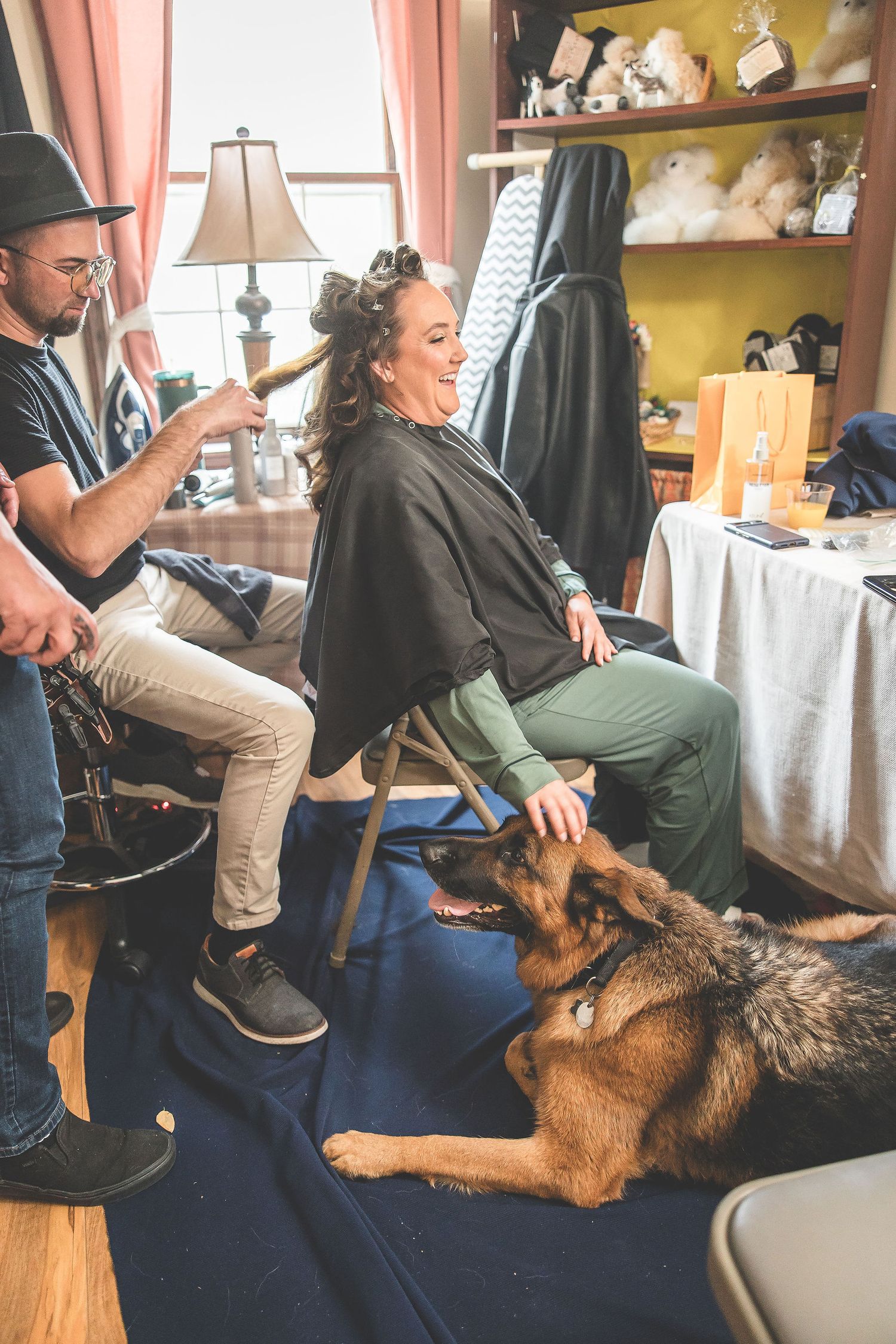 A German Shepherd dog interacts playfully with someone on a blue couch in a home setting.