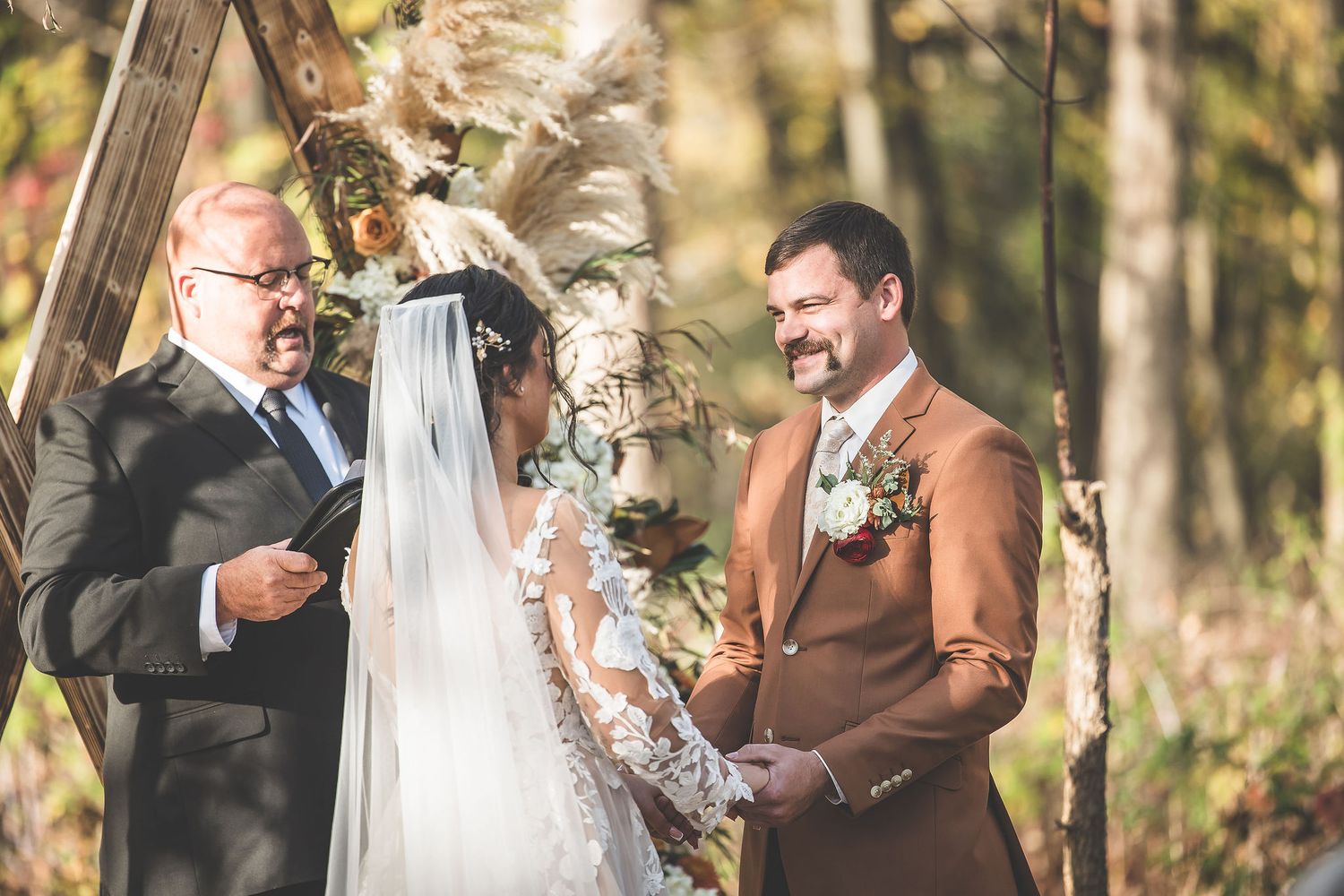 Intimate forest wedding ceremony with autumn foliage creating natural backdrop.