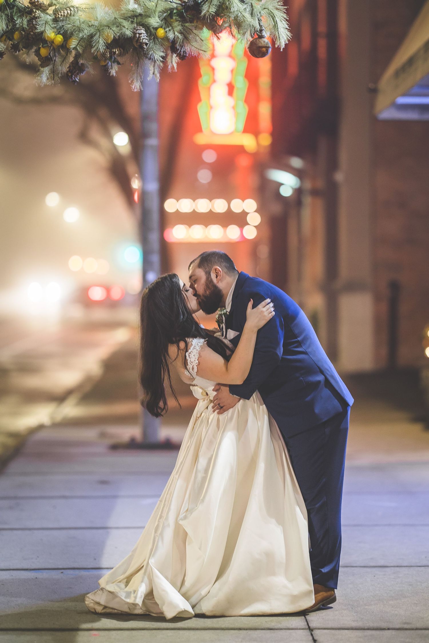 Romantic evening scene with string lights and illuminated storefronts creating ambient glow.