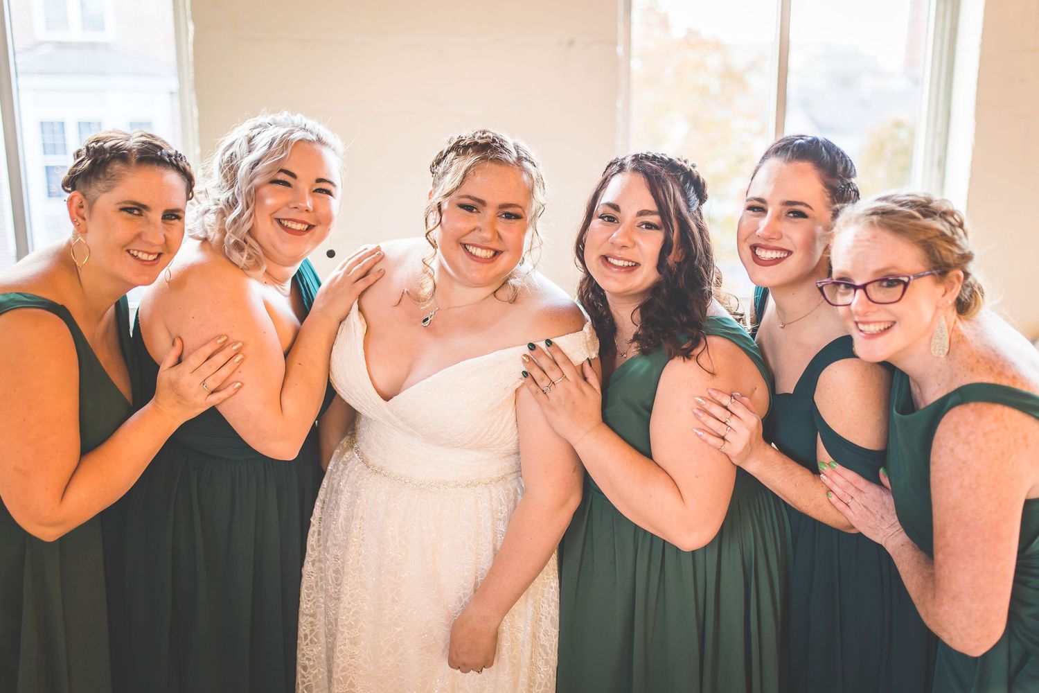 Wedding party members sharing joyful moments in an indoor setting.