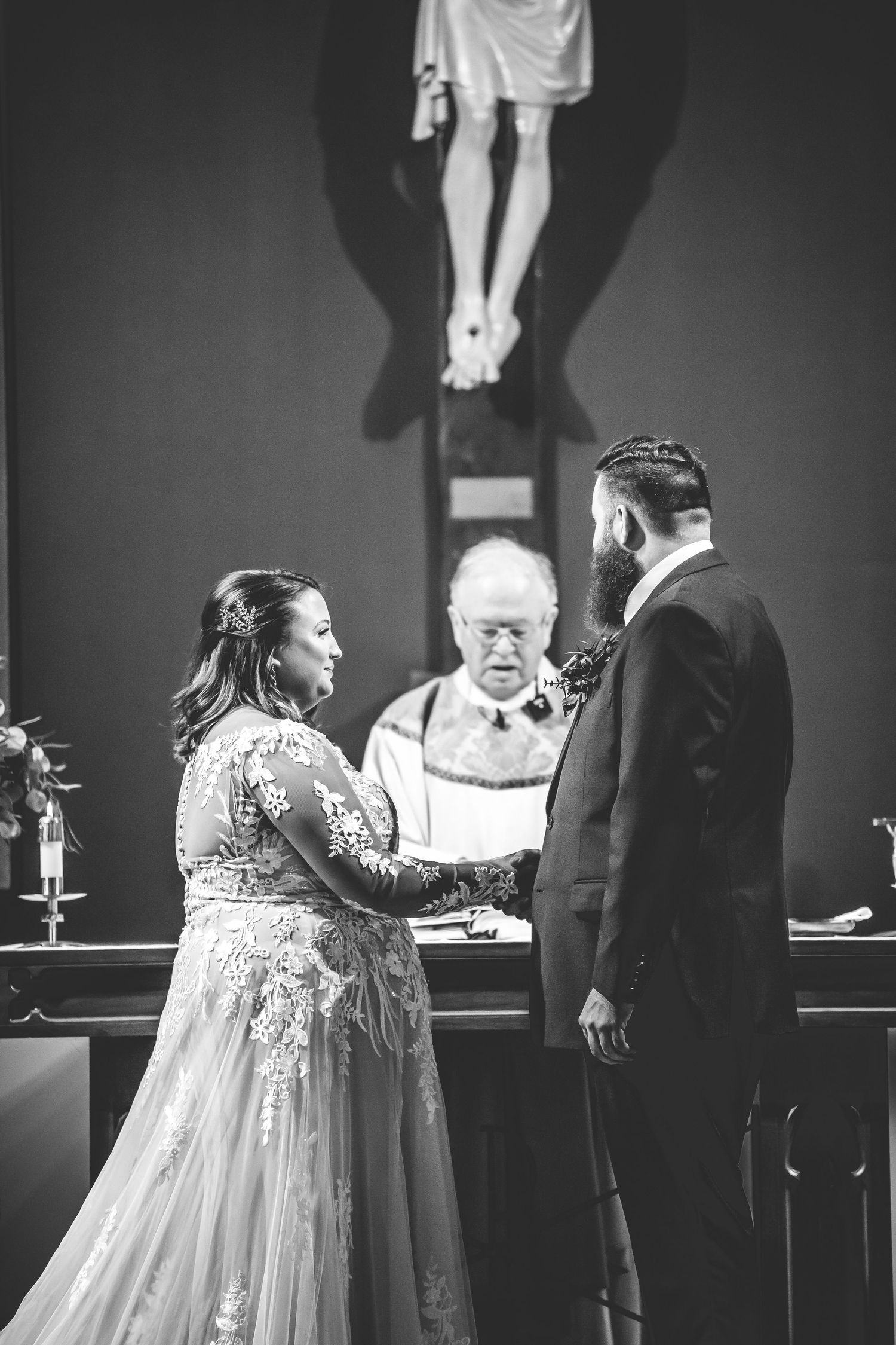 A wedding ceremony taking place in a church with a white lace dress and formal attire.