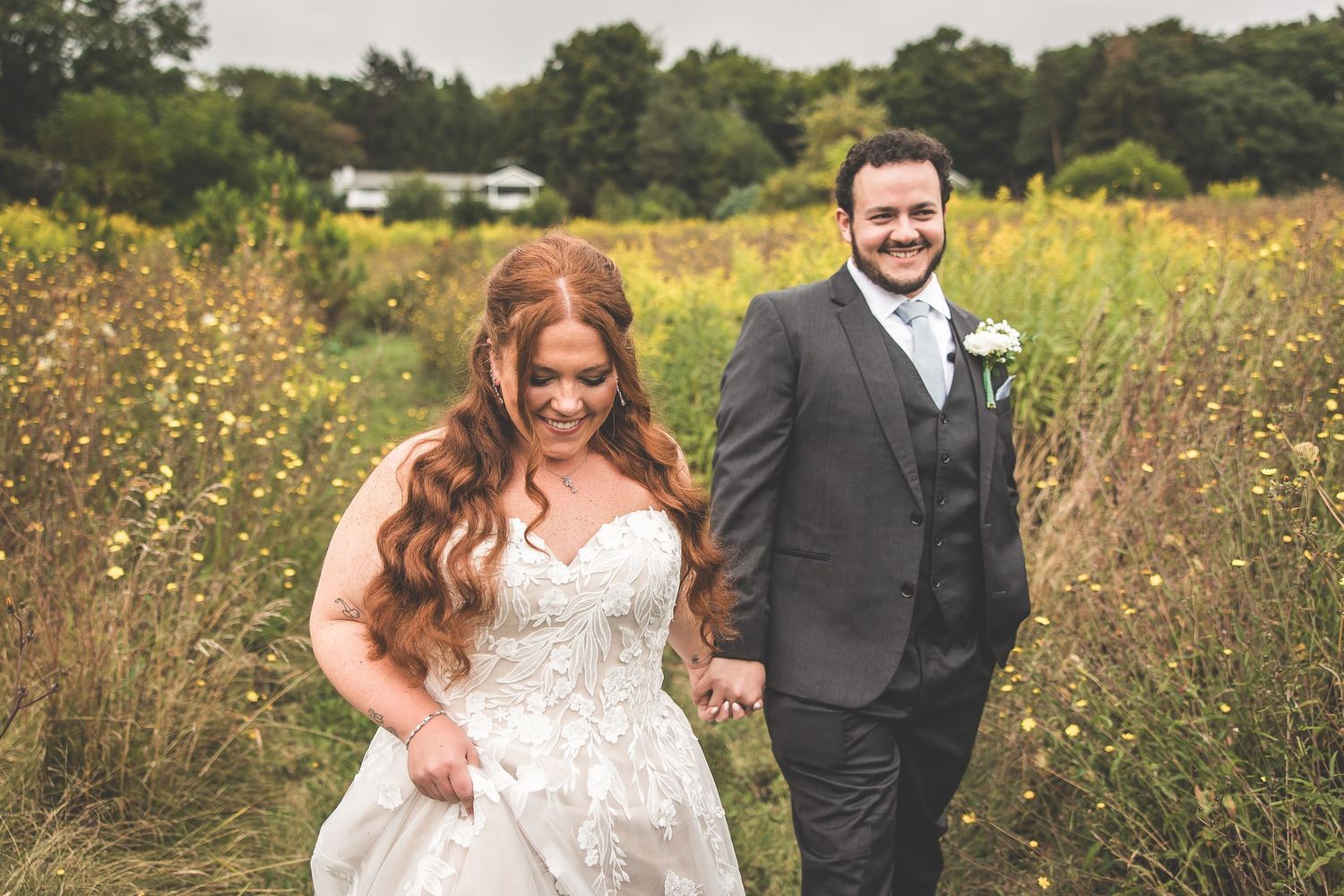 Wedding couple shares joyful moments in a sunlit wildflower field.