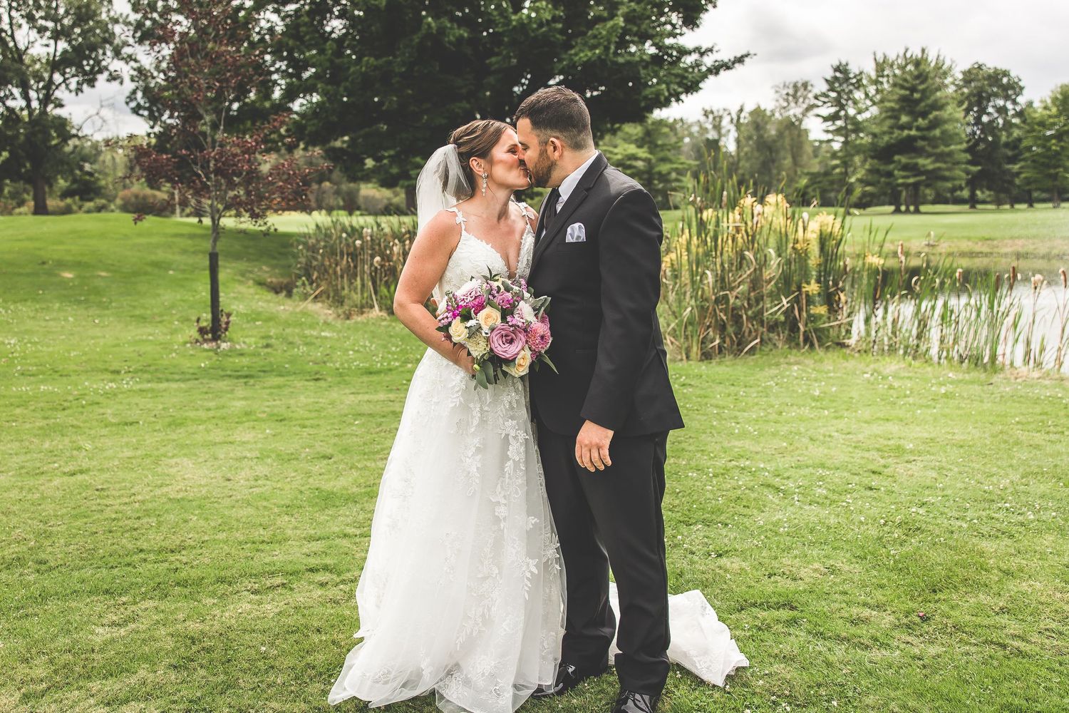 Romantic wedding photos captured near a pond with fountain in the background.