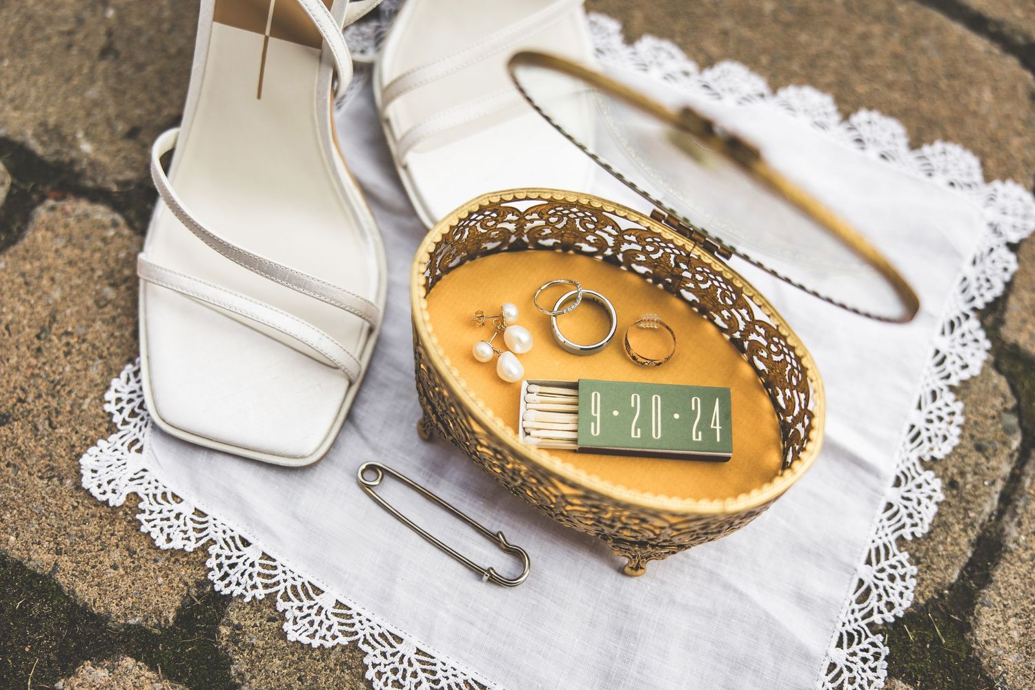 Wedding rings and decorative details displayed on delicate lace doily.