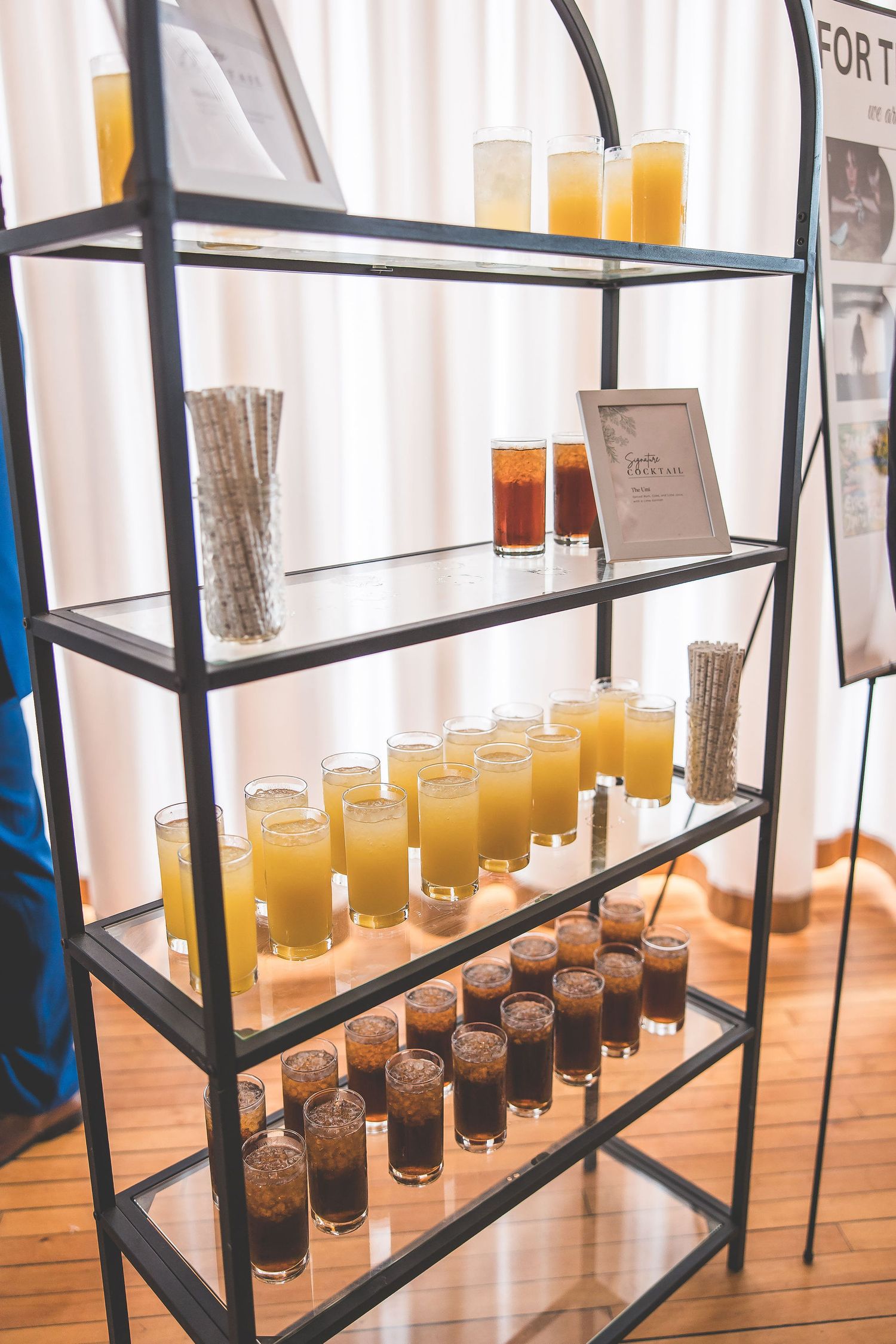 Display shelves featuring rows of signature cocktails in glass containers.