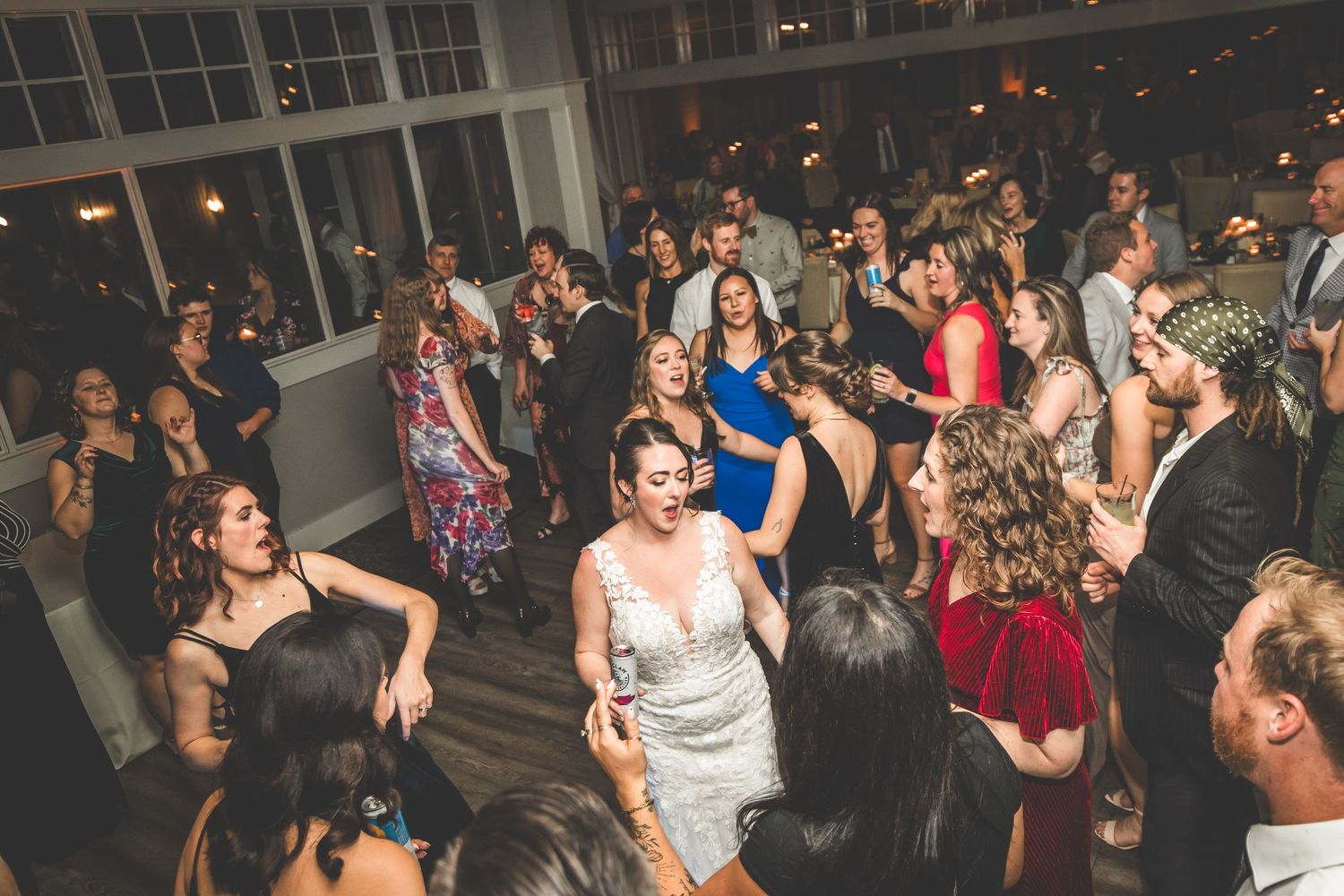 Crowded dance floor at wedding reception with guests enjoying upbeat celebration.
