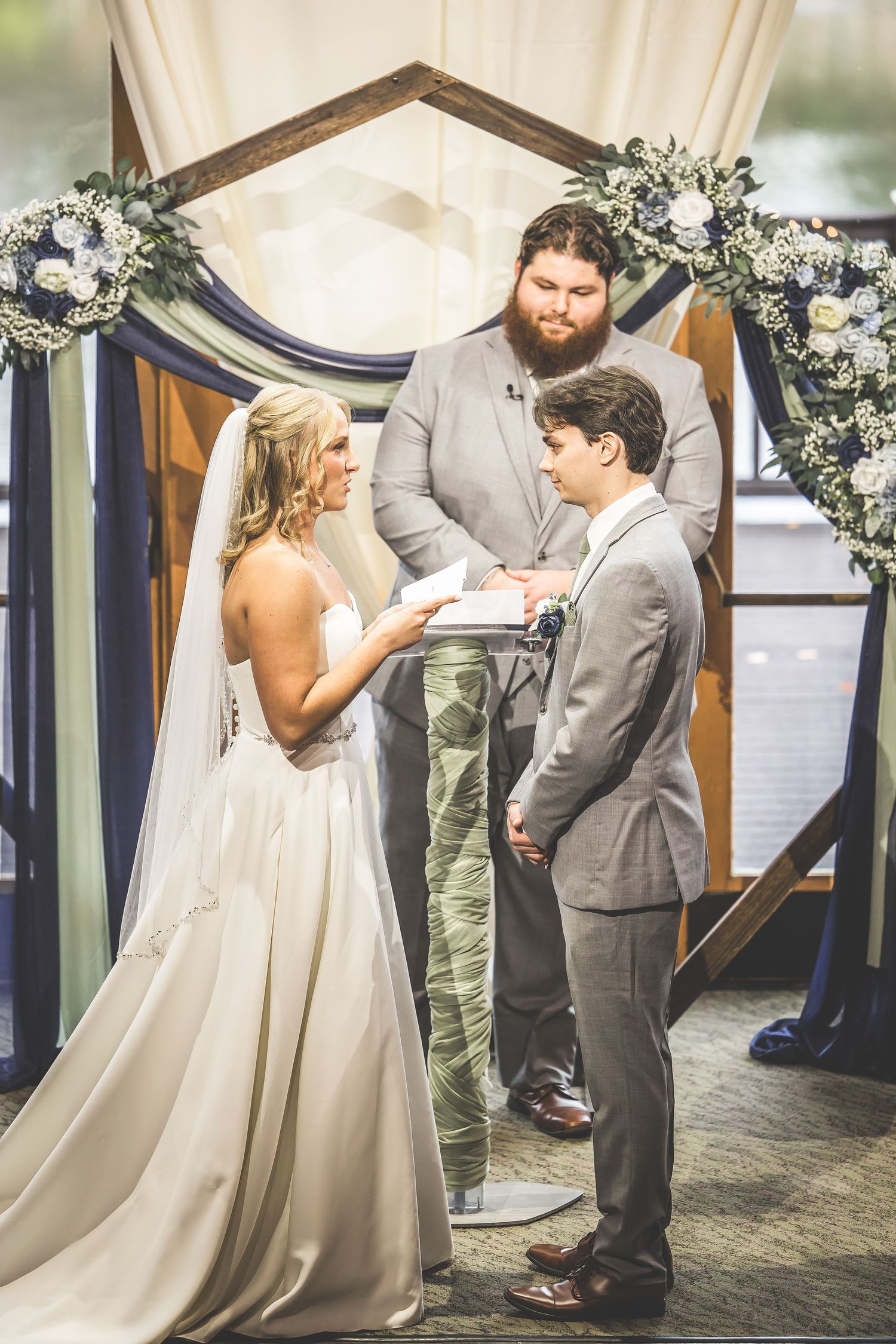 A sequence of wedding ceremony moments captured under an arch with white drapes and floral arrangements.