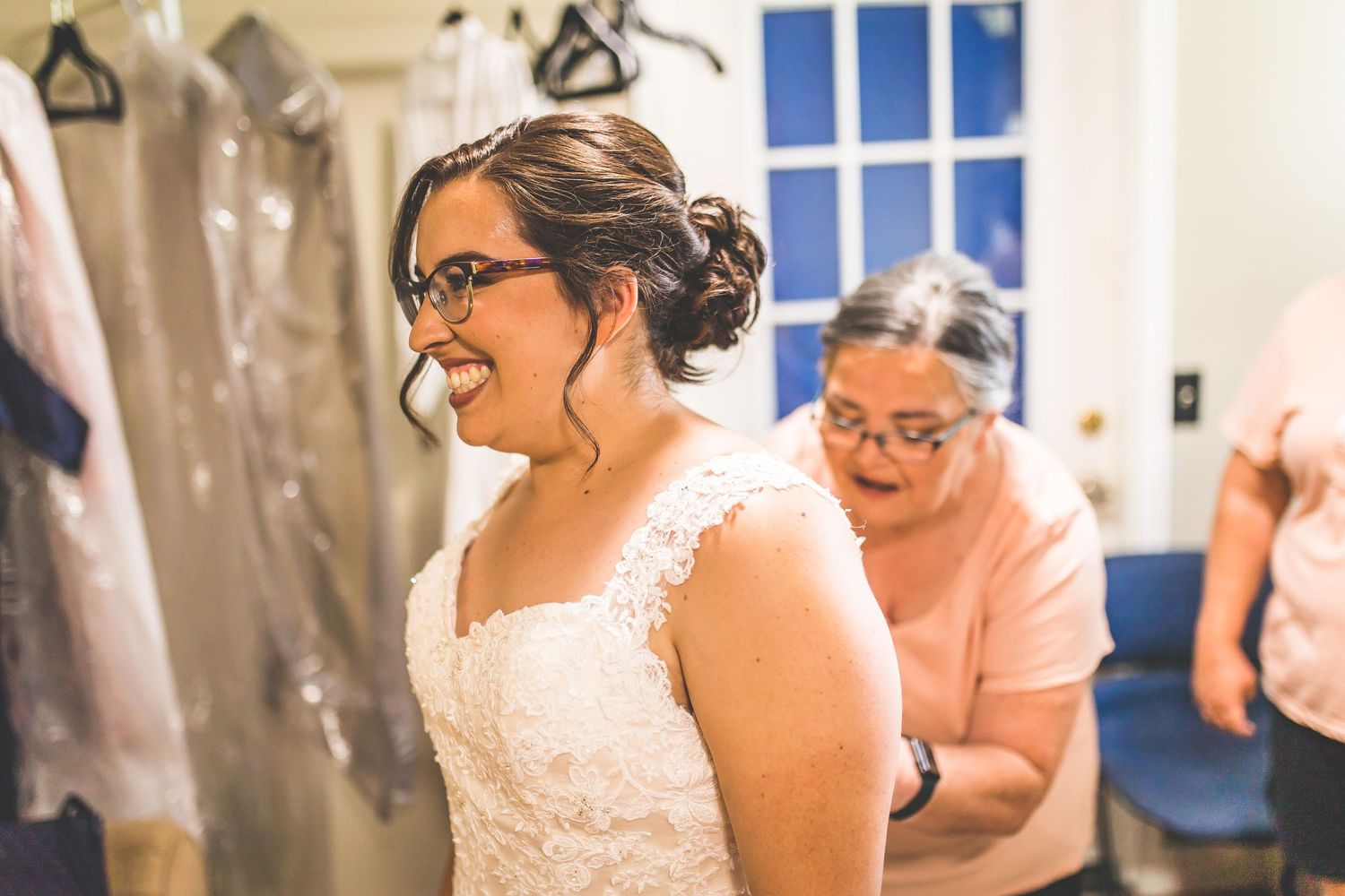 Wedding party members sharing emotional moments during preparations in an indoor venue.
