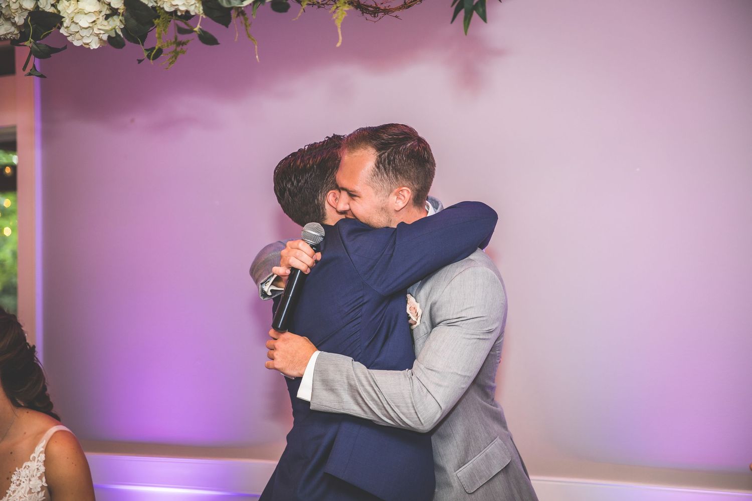 Emotional wedding reception scene with guests embracing during heartfelt moments.